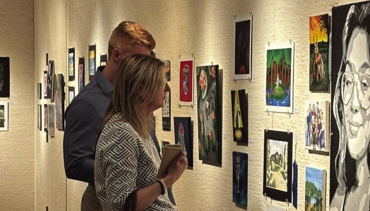 Visitors looking at the High School Juried Art Exhibit during the opening reception. Photo provided by Mabee-Gerrer Museum of Art
