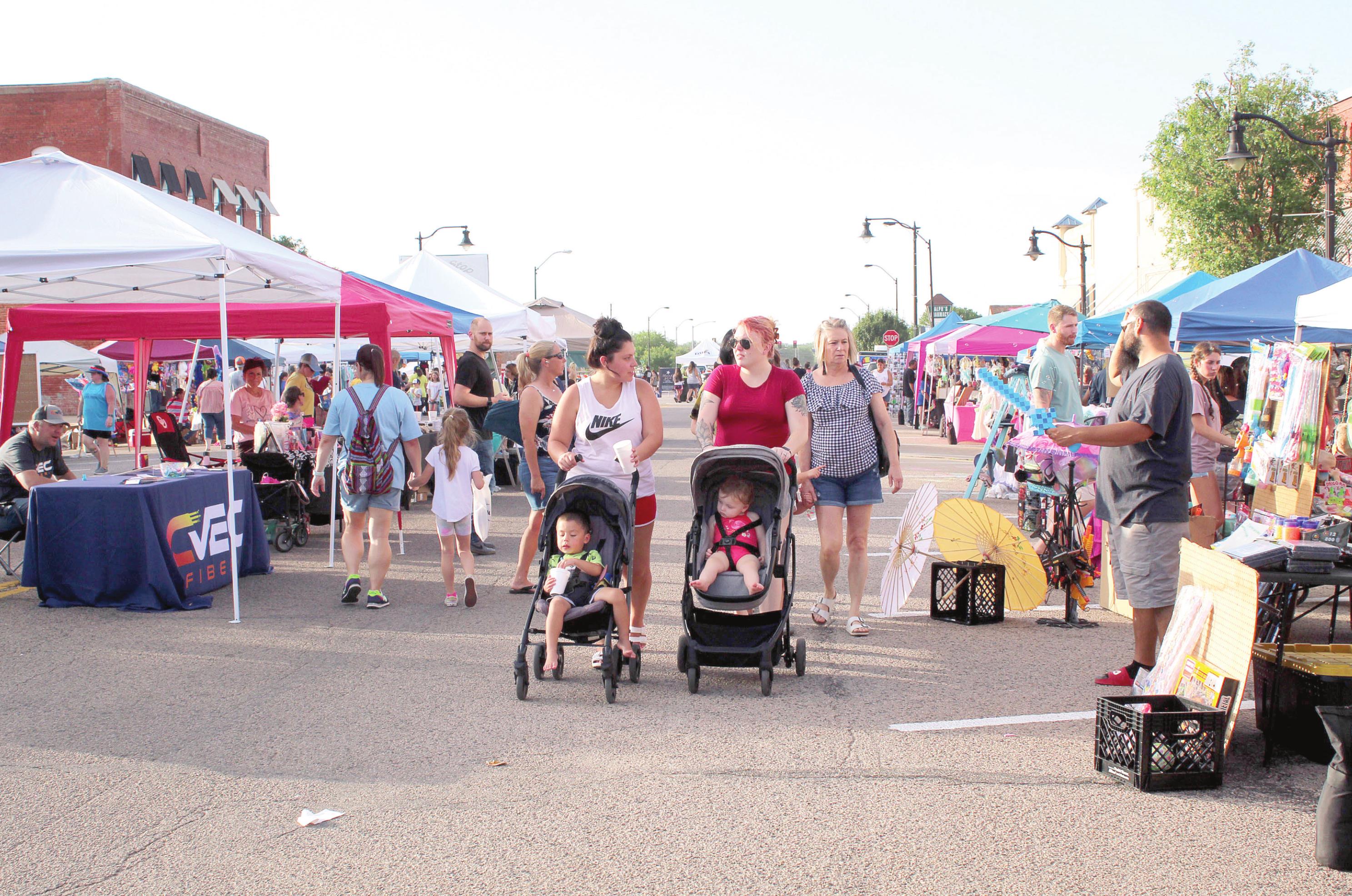Event-goers browse through 87 vendor booths at the Mingle on Main Street Block Party, in Tecumseh, on June 16. Countywide & Sun/Natasha Dunagan