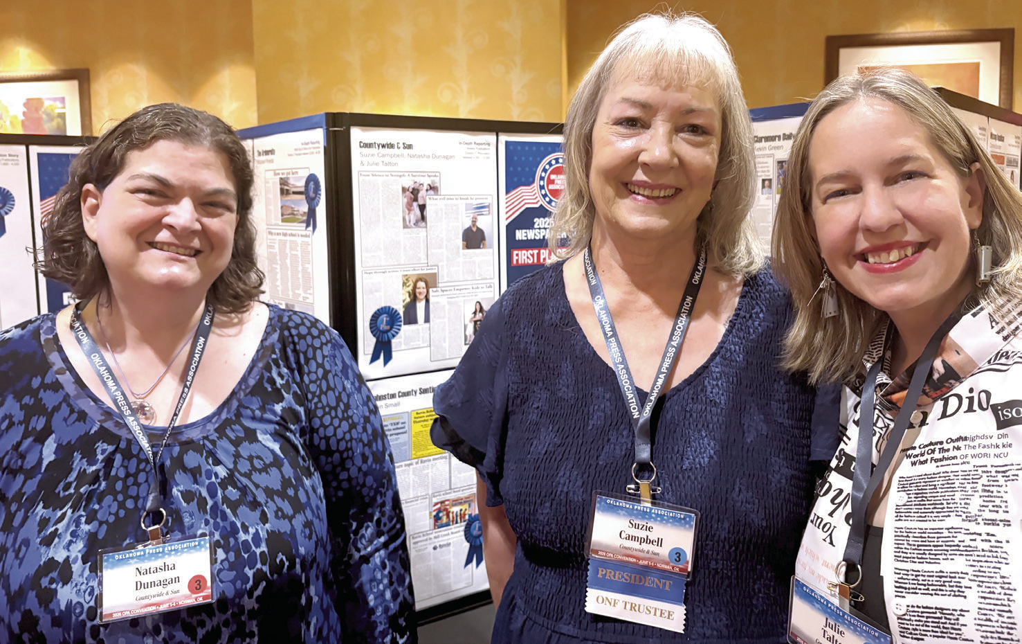 The Countywide & Sun's Natasha Dunagan, Suzie Campbell, and Julie Talton pose in front of the first place In-Depth Reporting page. The team brought home multiple awards in its division at the Oklahoma Press Association's annual Better Newspaper Contest.