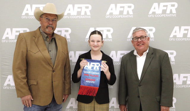 Bethel 4-H Member Taycie Baker poses with AFR Cooperative Vice President Toby Wallace, left, and AFR Cooperative President Scott Blubaugh after winning second place in the AFR Central District Speech Contest Junior Division on Nov. 10. Photo provided