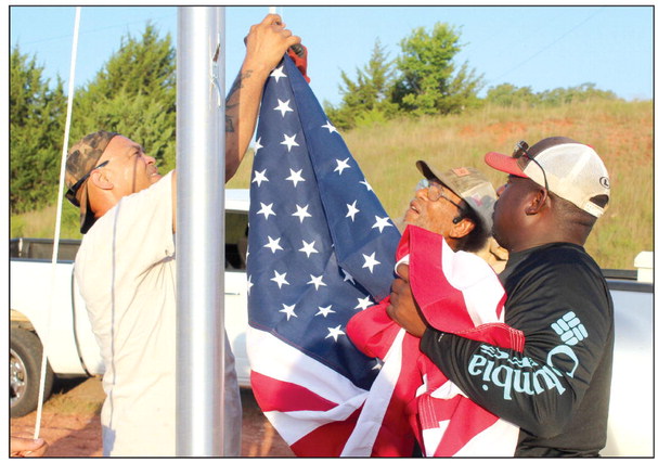 Shawn Edwards, Franklin Edwards and Clarence Bernard attach the U.S. flag to hoist it for the first time on a newly installed 25-foot flagpole at the Brooksville town limits, June 29. Frank Phillips, not shown, said they plan to add lights around the pole, and there will be a “Welcome to Brooksville” sign near it, as well. Countywide & Sun/Natasha Dunagan