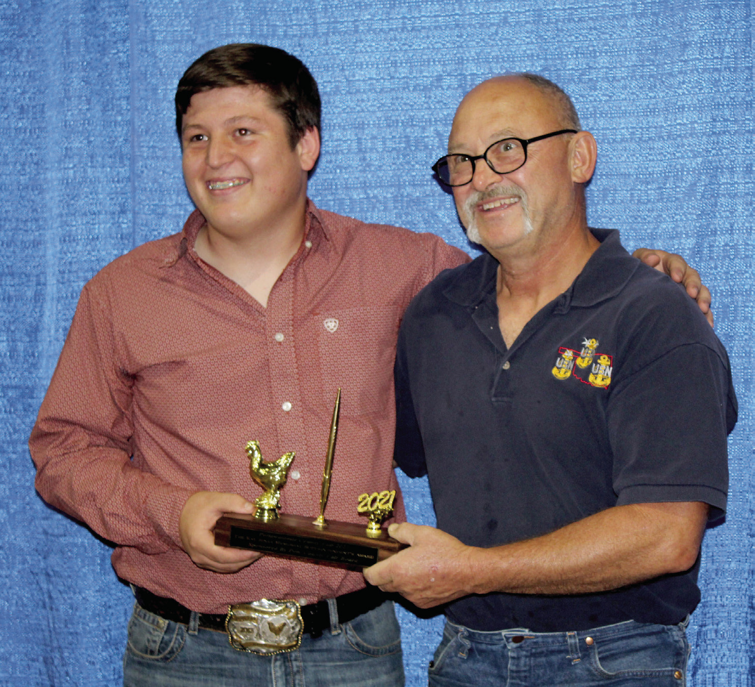 Bethel graduate Michael St. Clair presents Jimmy Story with the Kay Jenks Memorial Superintendent’s Award for being an outstanding volunteer in the poultry division in 2021. File photo.