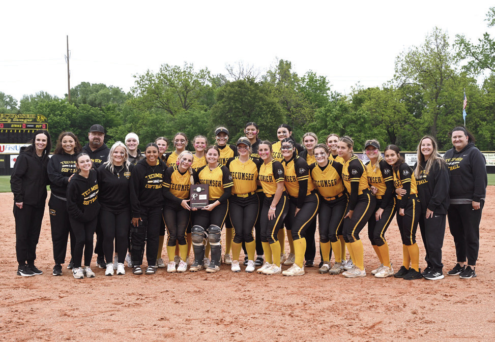 The Tecumseh Lady Savages Slow Pitch Team, along with their coaches, managers and athletic director, pose after winning their Class 5A Slow Pitch District Tournament at home. On April 22, they beat Harding Charter, 23-0, and Purcell, 11-1. Then, on April 23, they beat Purcell again, 13-0. Photo courtesy of Kenetta Lisenbee