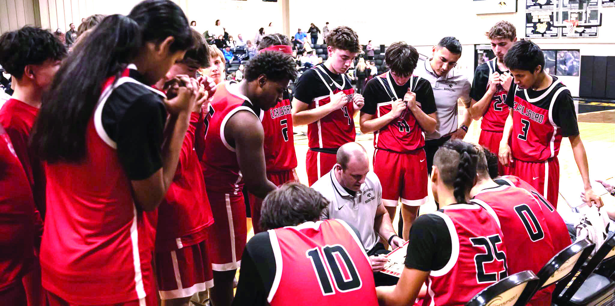 The Earlsboro Wildcats huddle around Coach Chad Rochelle during a tight game in Roff.