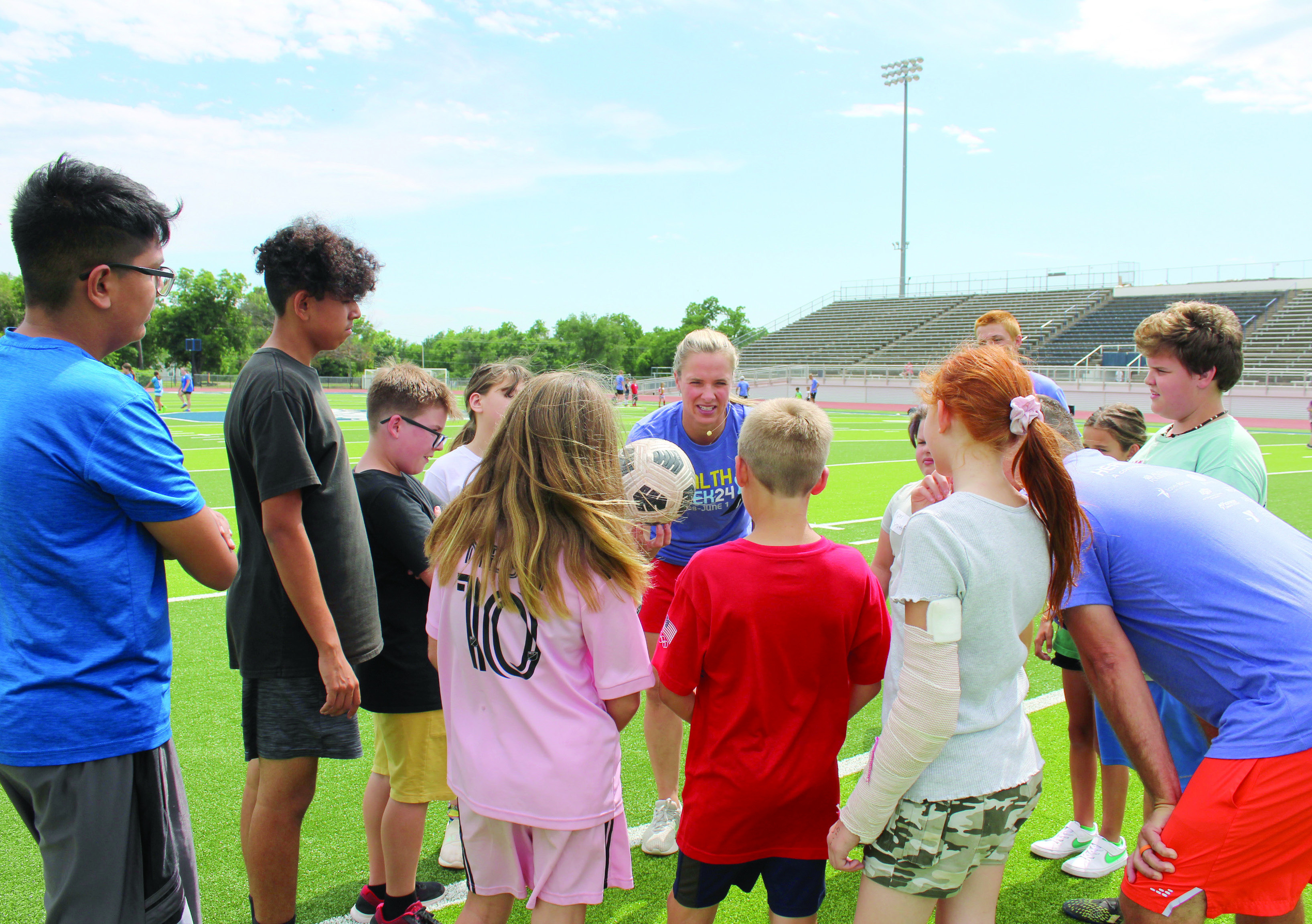 Lindsay Tarpley reminds one group of kids what they need to work on during her soccer demonstration, sponsored by POGO for Health Week, at Jim Thorpe Stadium, May 28. About 50 children, ages 6-15, participated in the event, and 20 volunteer coaches led groups in the instructional practice. Tarpley was on the U.S. Women's National Soccer Team when they won the Gold Medal in both 2004 and 2008. She now co-owns World Champion Soccer Academy with her husband and is a keynote speaker.