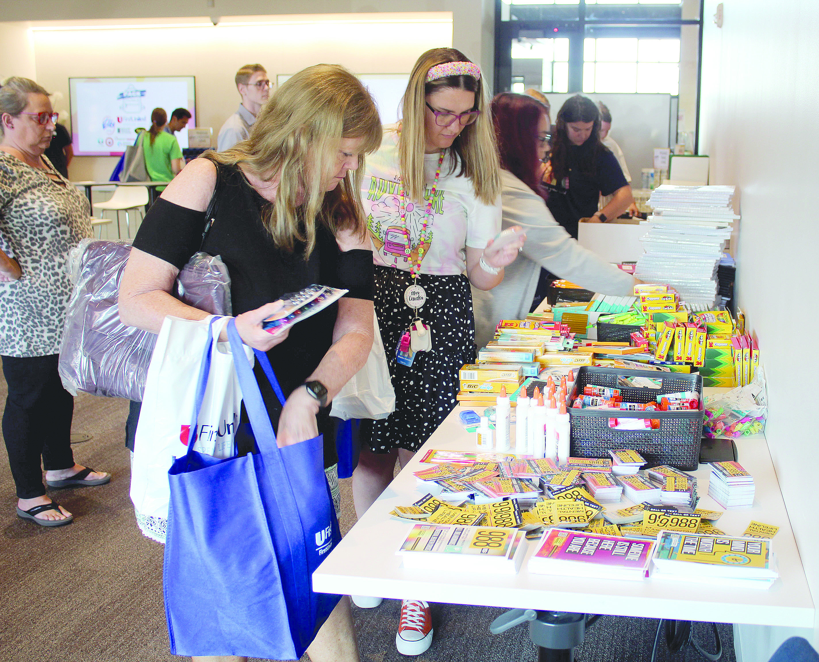 Horace Mann Elementary third-grade teacher Janet Hopper, Will Rogers Elementary fourth-grade teacher Shelby Cowden, and Shawnee Middle School eighth-grade math teacher Stephanie Bayne select school supplies during the Second Annual Pack the School Teacher Supply Stop, held at First United Bank's Harrison branch in Shawnee on Aug. 1. Hopper has been a teacher for 29 years and said she spends over $200 on supplies each year.