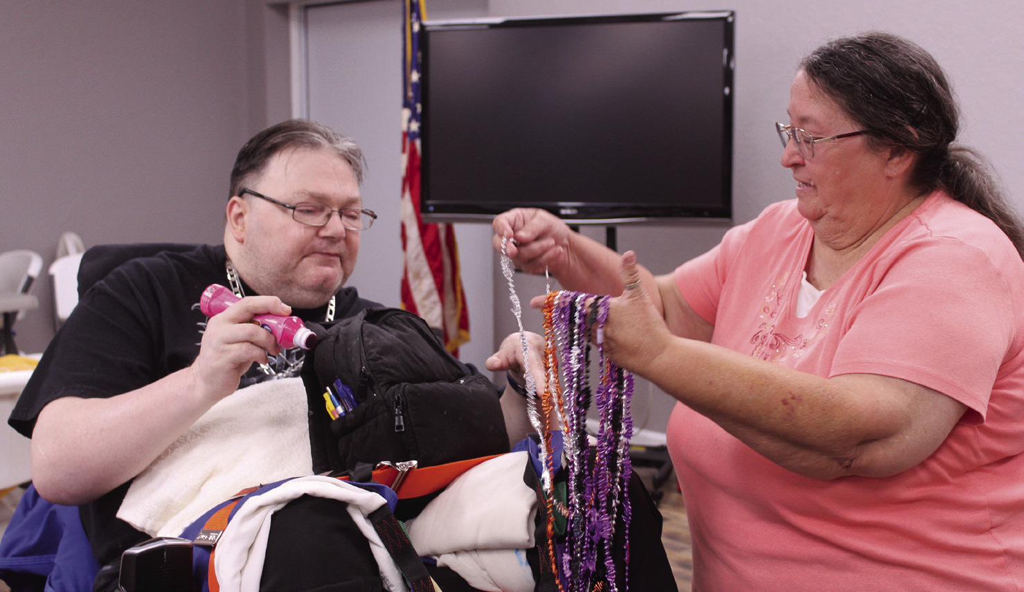 Shawnee American Legion Auxiliary Vice President Jamie McCraw offers a necklace to Billy Heavner during the monthly bingo for nursing home residents at American Legion Gill-Mattox Post 16 on Oct. 15. This is the third time the post has held the special bingo event, which is on the third Wednesday of each month now. Natasha Dunagan, Countywide &amp; Sun