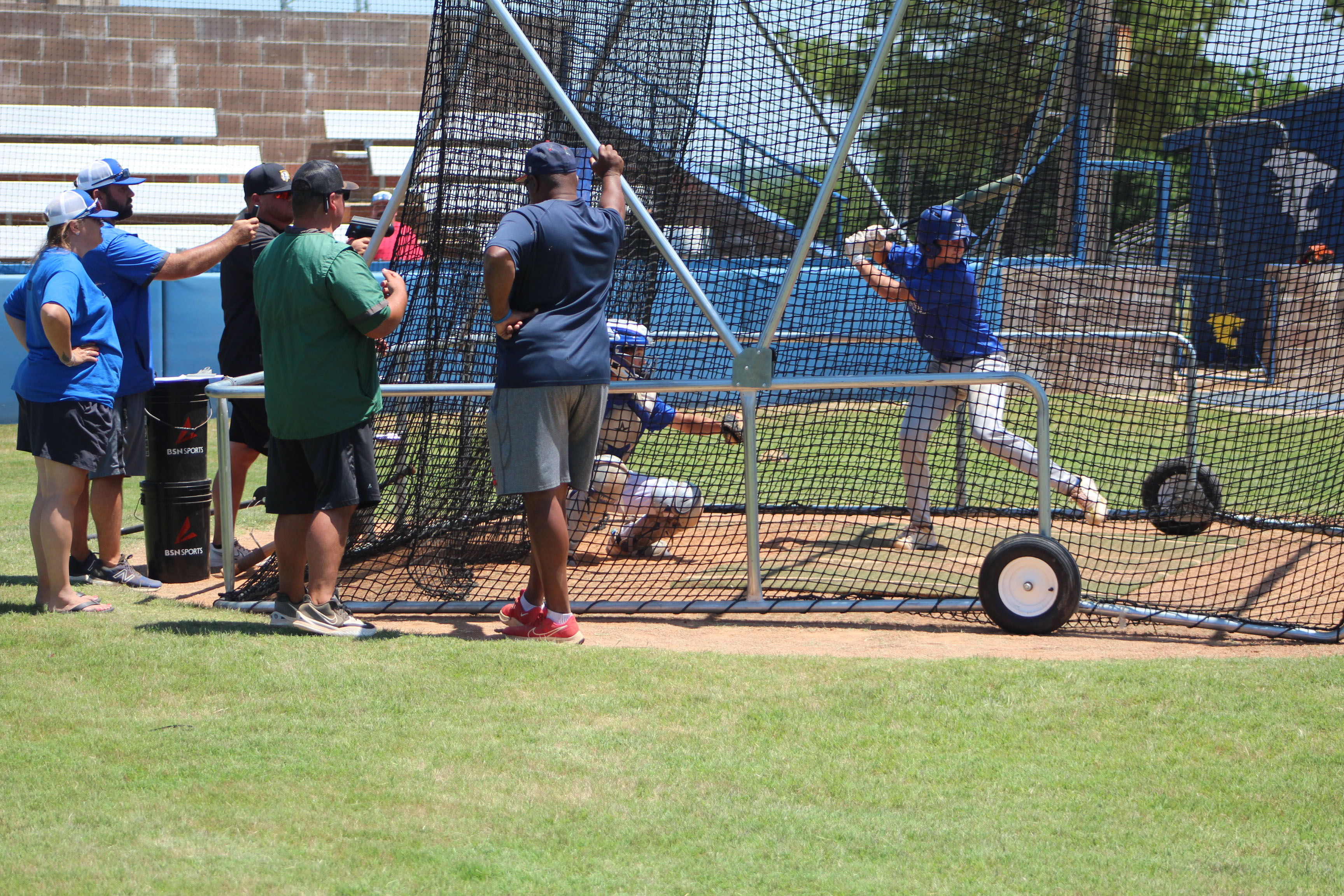 Matthew Sharp bats and Roger Brooks catches, both of Bethel, as Bethel Coach Lincoln Dearing, second from left, clocks bat exit velocity with a pocket rader, and Tecumseh Coach Easton Marrs, third from left, clocks pitching velocity during the First Annual Pottawatomie County Prospect Camp, held at Bethel on June 27. Also shown, from left, are Andrea Brooks, who helped with camp registration; Cody Painter, of Oklahoma Baptist University; and James Martin, of Seminole State College. 