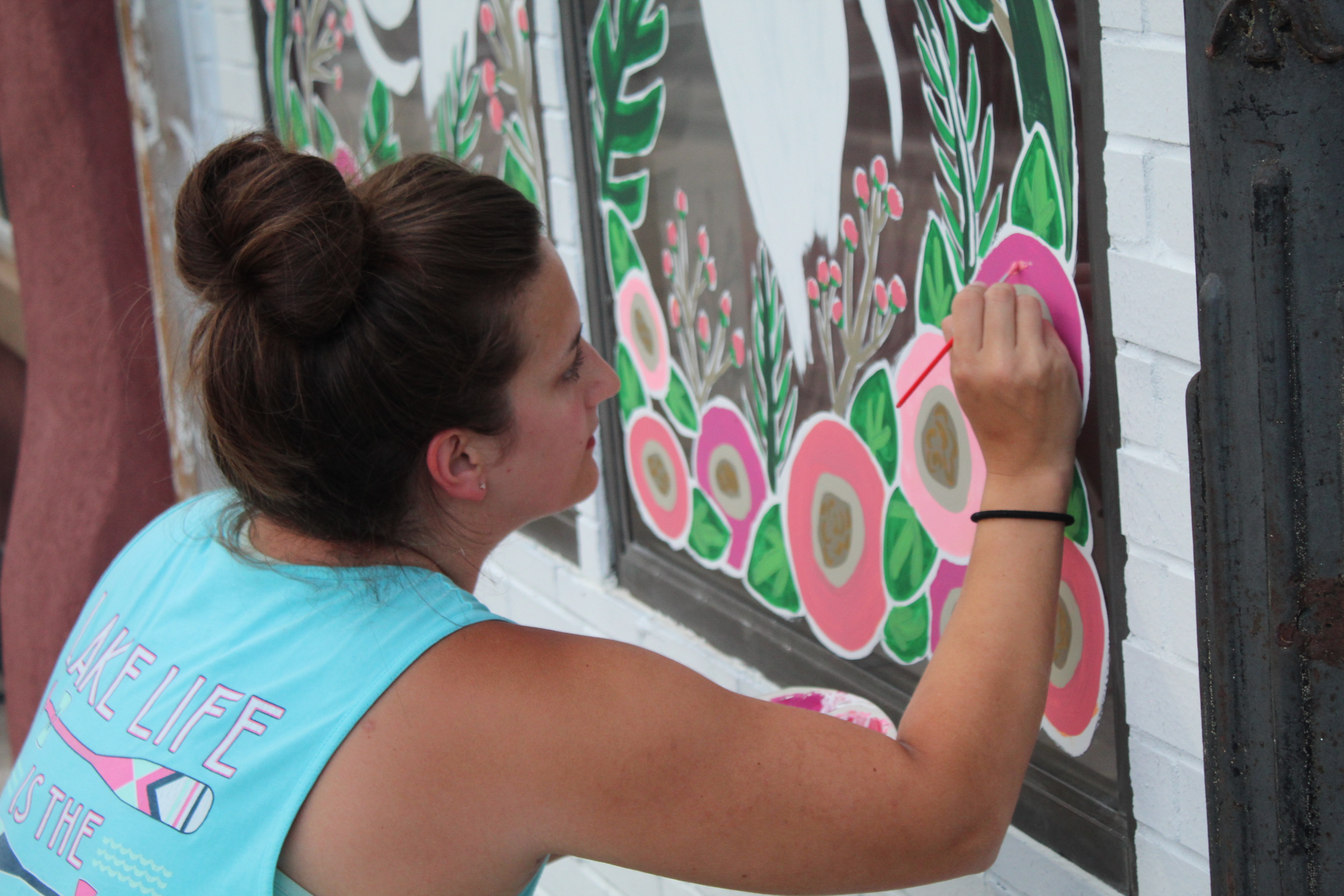 Lizzy Brady paints the Beauty Barn's windows.