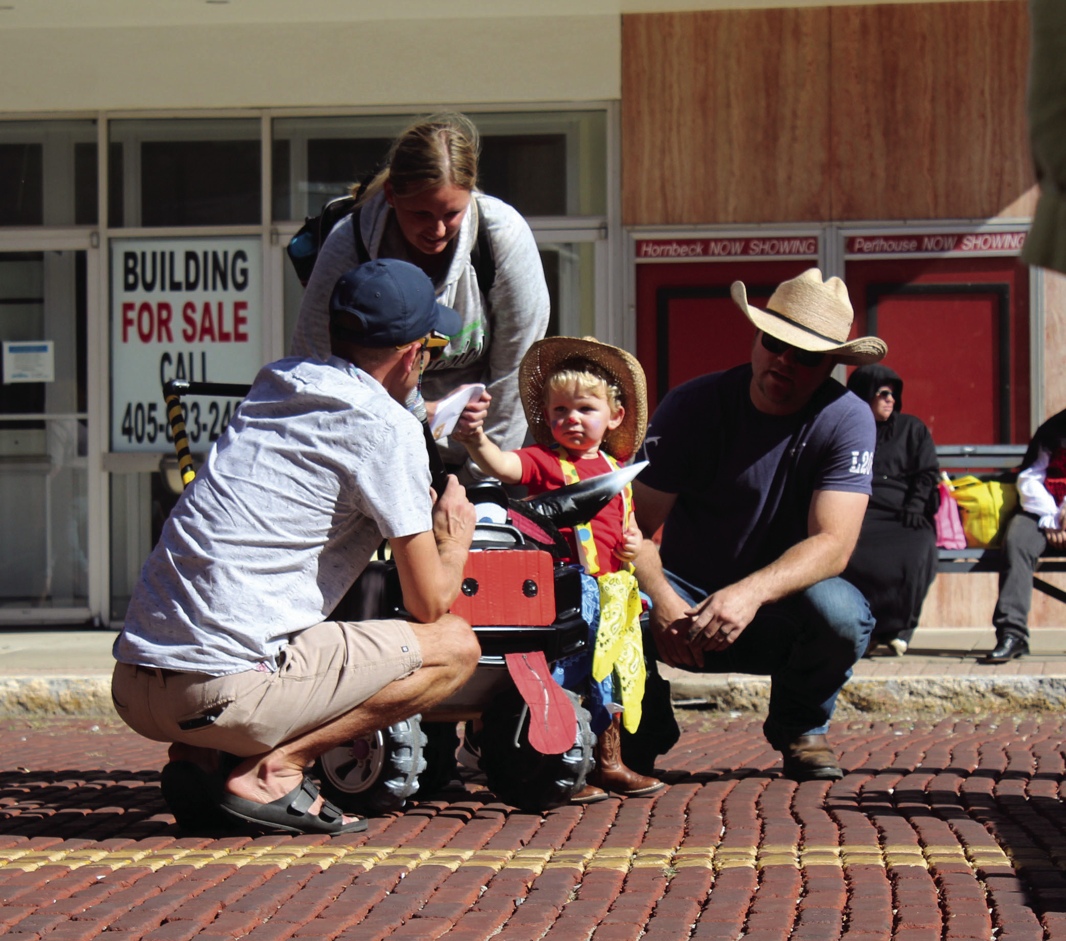 “Rodeo Clown” Layton Cannon, of Shawnee, fist bumps M.C. Waylon Sewell, as his parents Brittany and Bo Cannon look on during the 0-3 year costume contest at Monsters on Main in downtown Shawnee, Oct. 22. Bo Cannon is actually a firefighter clown for fire prevention presentations. Layton won third place. Countywide & Sun/Natasha Dunagan