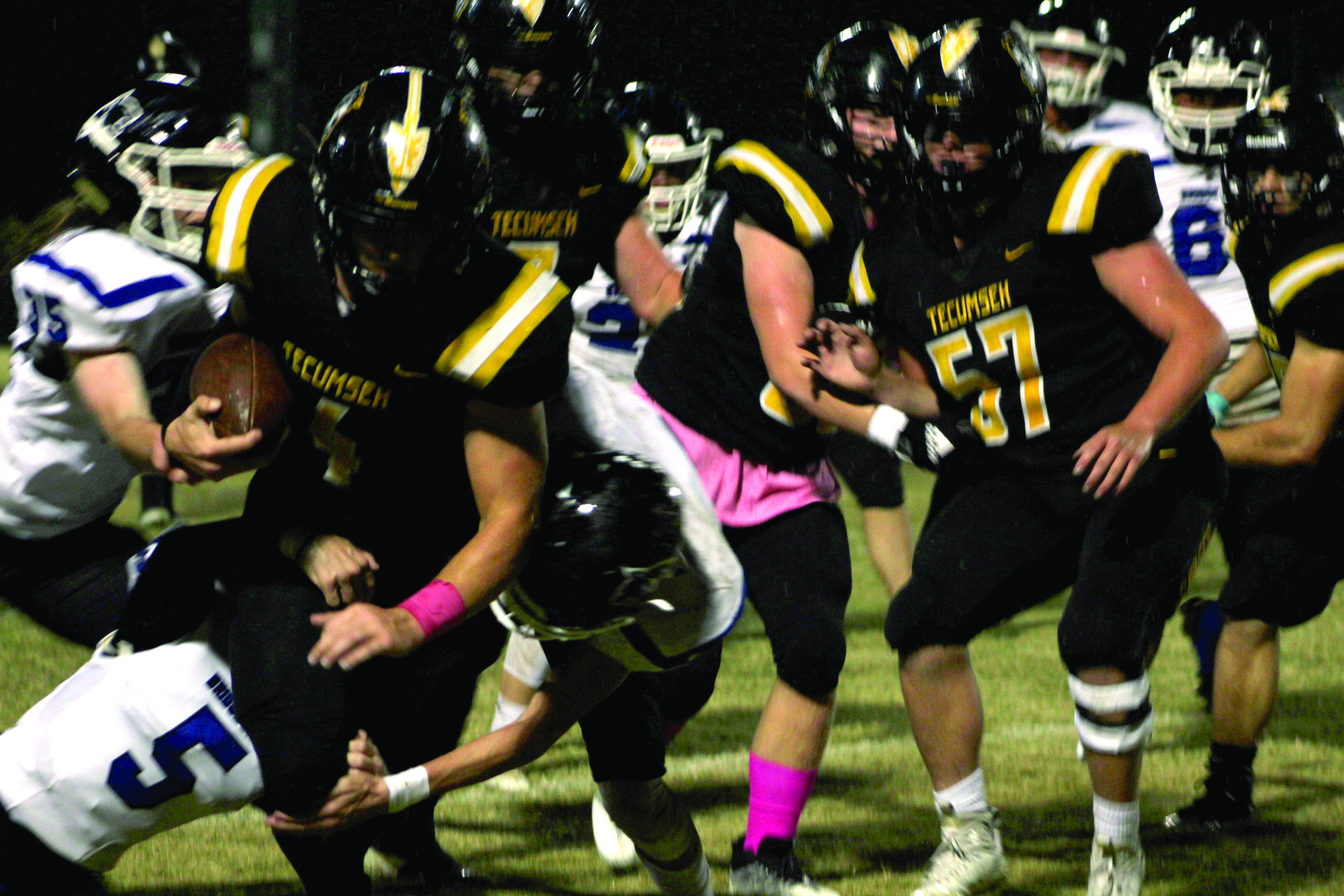 Tecumseh senior Garrett Chaffin (#4) carries the ball during the first quarter as Bridge Creek defenders try to trip him up. Despite rain, the Savages won the Pink Out home game on Oct. 28, 39-14. Countywide & Sun/Natasha Dunagan