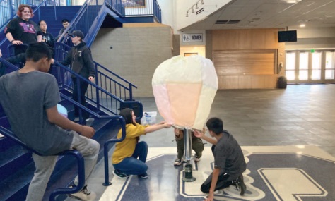 Eliana Rao, Kourgar Simons and Chris Larney launch a tissue paper hot air balloon they created in the Shawnee High School Performing Arts and Activities Center. This was one project done this year in the "Launching Into Aviation" class. Photo provided by Joshua Watson.
