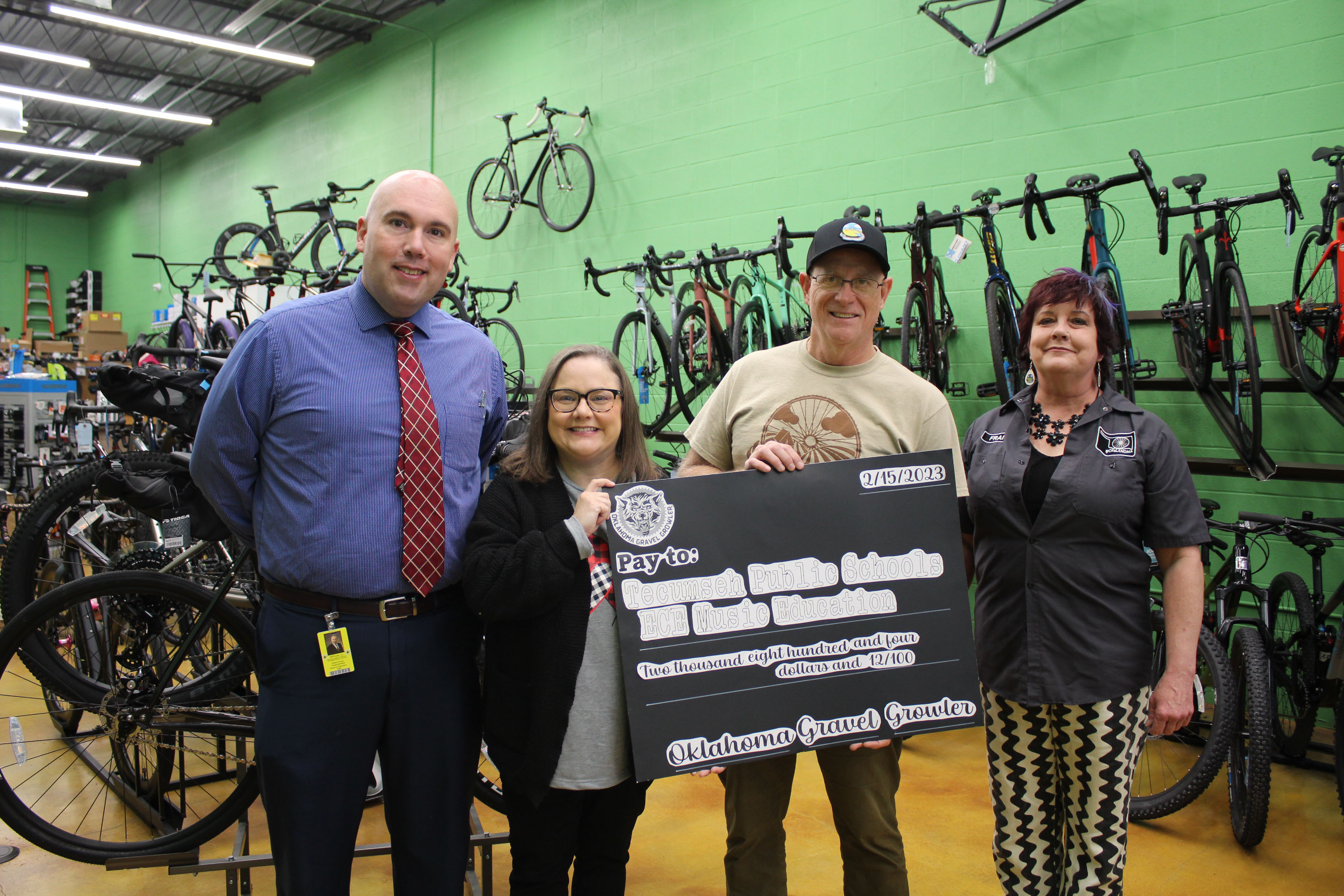Tecumseh Superintendent Robert Kinsey and Tecumseh Early Childhood Center Principal Tammy Giaudrone accept a check from spOKeLAHOMA co-owners Craig MacIntyre and Fran Topping on Feb. 15. The $2,804.12 was raised from a scavenger hunt during the Oklahoma Gravel Growler in which bicyclists could pay $10 to participate on Feb. 4. Giaudrone said the money will go toward their Music Department, and they are looking at buying risers. Countywide & Sun/Natasha Dunagan