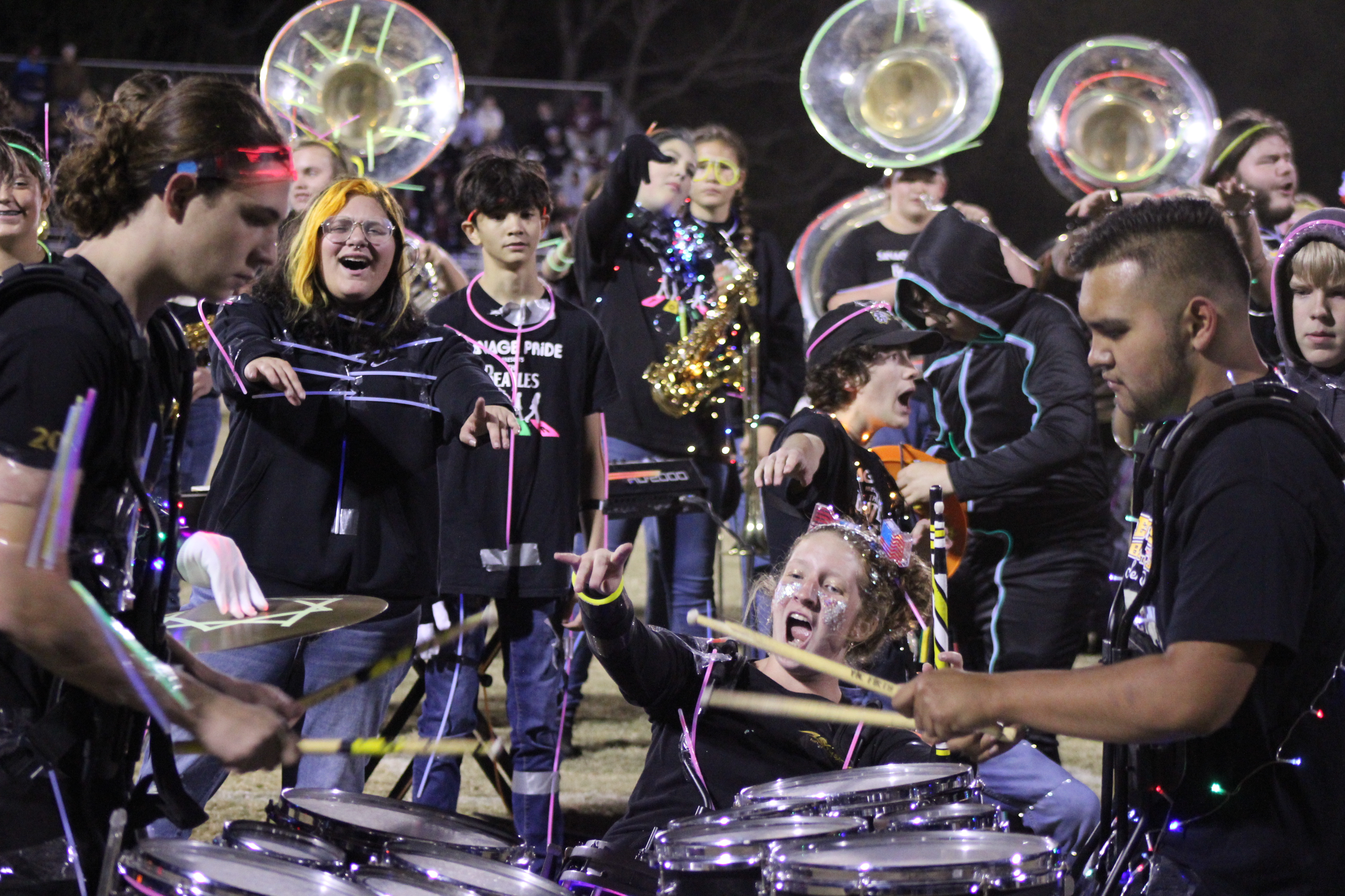 Tecumseh drummer Laycee Thoma cheers on fellow drummers Dalton Lewelling and Alan Lopez-Moreno, along with the rest of the band, following the annual light show at halftime of the Nov. 3 home game. Countywide & Sun/Natasha Dunagan