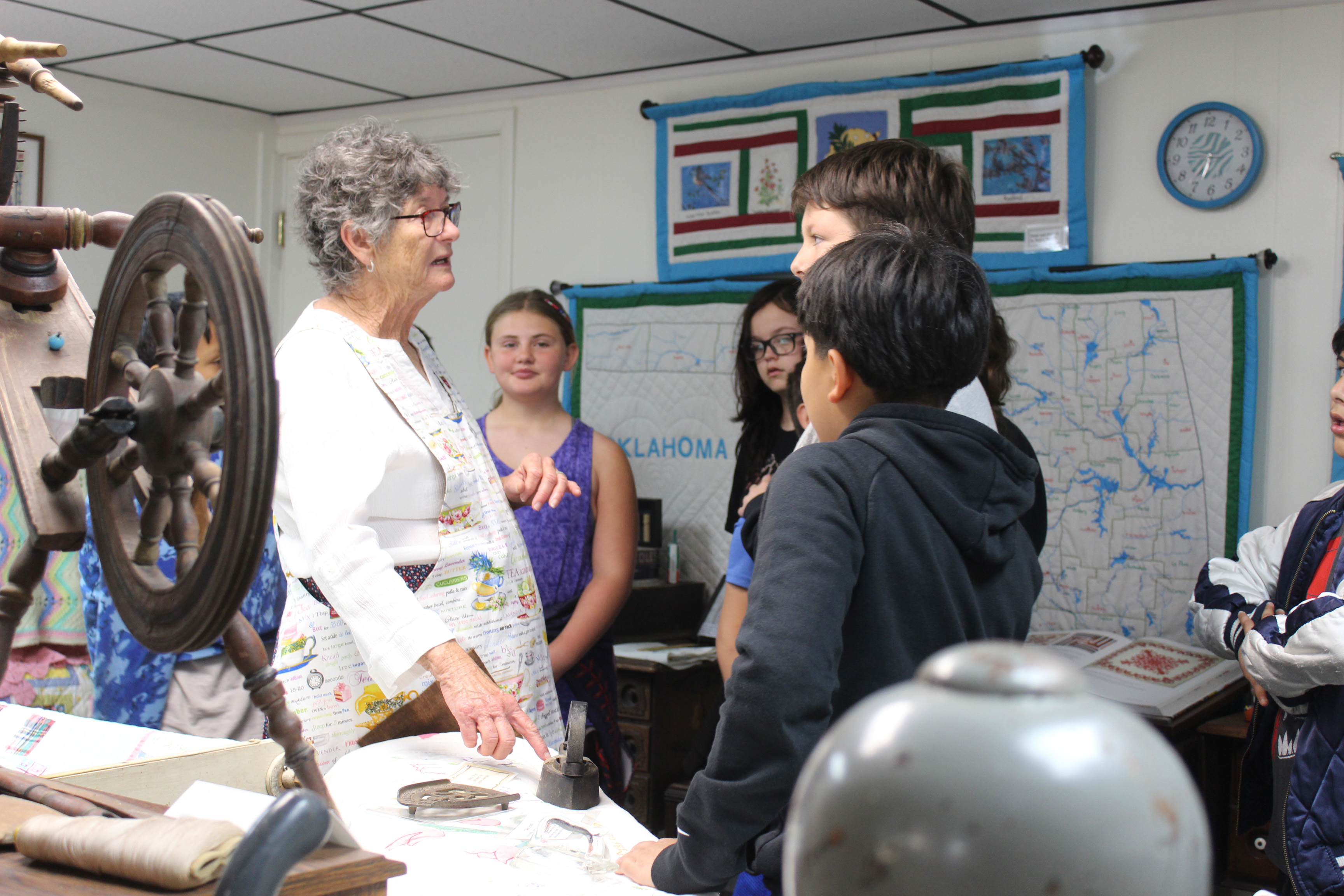 Jan Parker, a volunteer at the Tecumseh Historical Society Museum, tells fifth-graders from Cross Timbers Elementary about the sad iron during the annual tours on May 2. She also spoke about quilts, spinning wheels, aprons and other household items from the past. About seven classes visited the museum at 114 S. Broadway in Tecumseh. Countywide & Sun/Natasha Dunagan