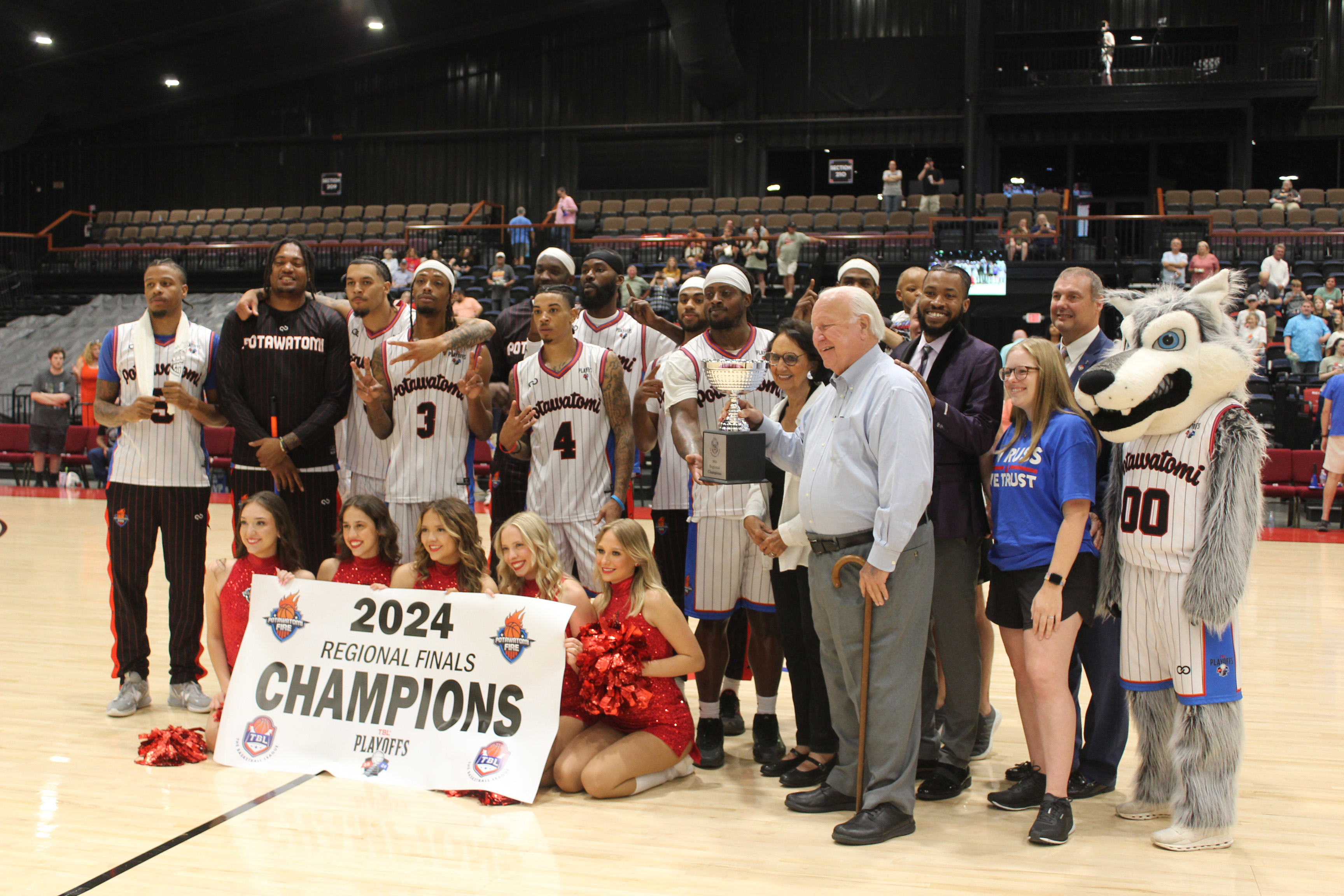The Potawatomi Fire team - along with Head Coach Mark Dannhoff and Assistant Coach Emmanuel Toney, Athletic Trainer Taylor Williams, the Fire Girls, and Citizen Potawatomi Nation Chairman John "Rocky" Barrett and Vice Chair Linda Capps - pose with the 2024 TBL Regional Finals Champions banner and trophy on June 15. They won the second western regional game against the Los Angeles Ignite, 120-96, making this their 26th straight win this season, according to potawatomifire.com.
