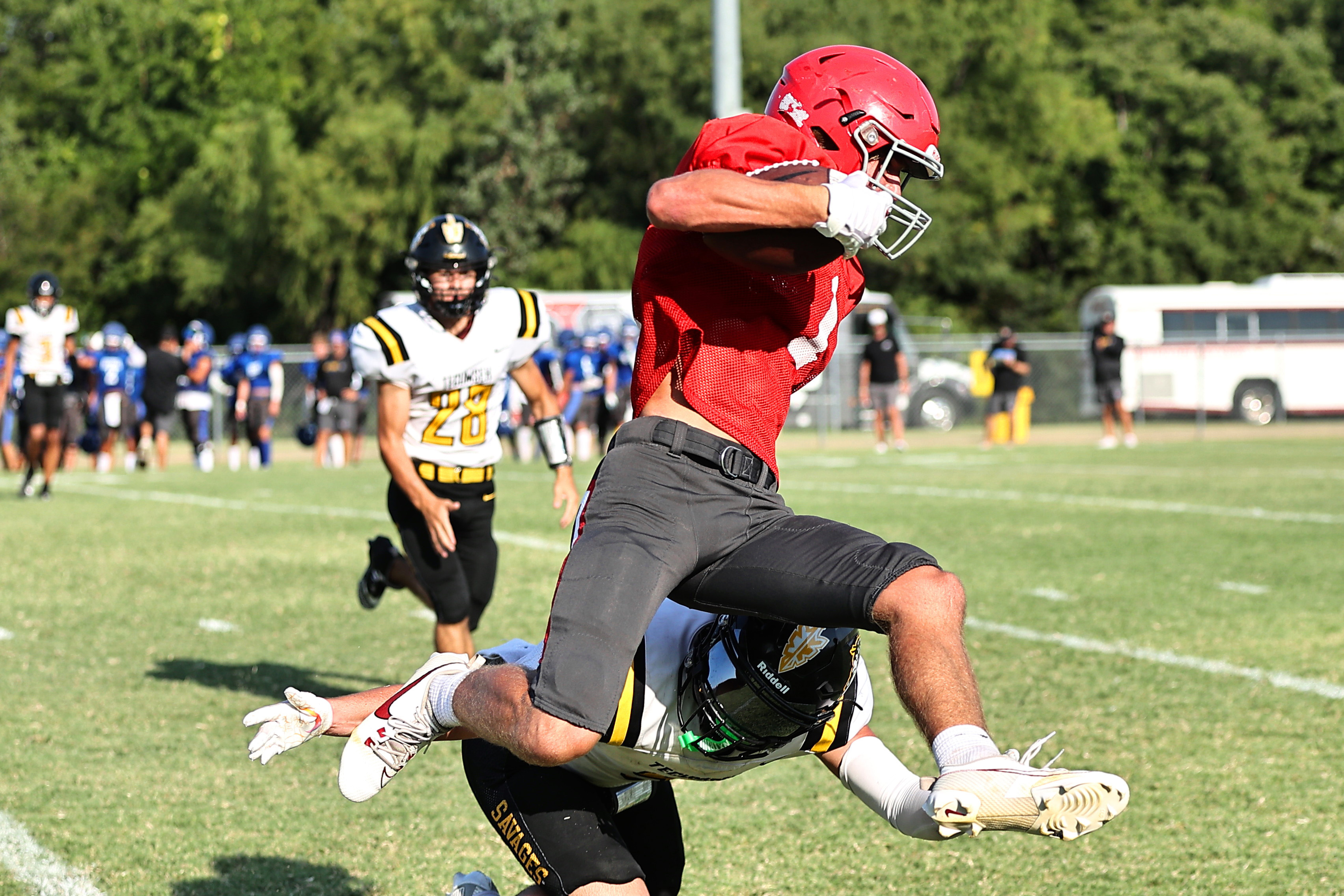 North Rock Creek's  CJ Stephens leaps over a Tecumseh defender. Photo courtesy of Gowin Photography