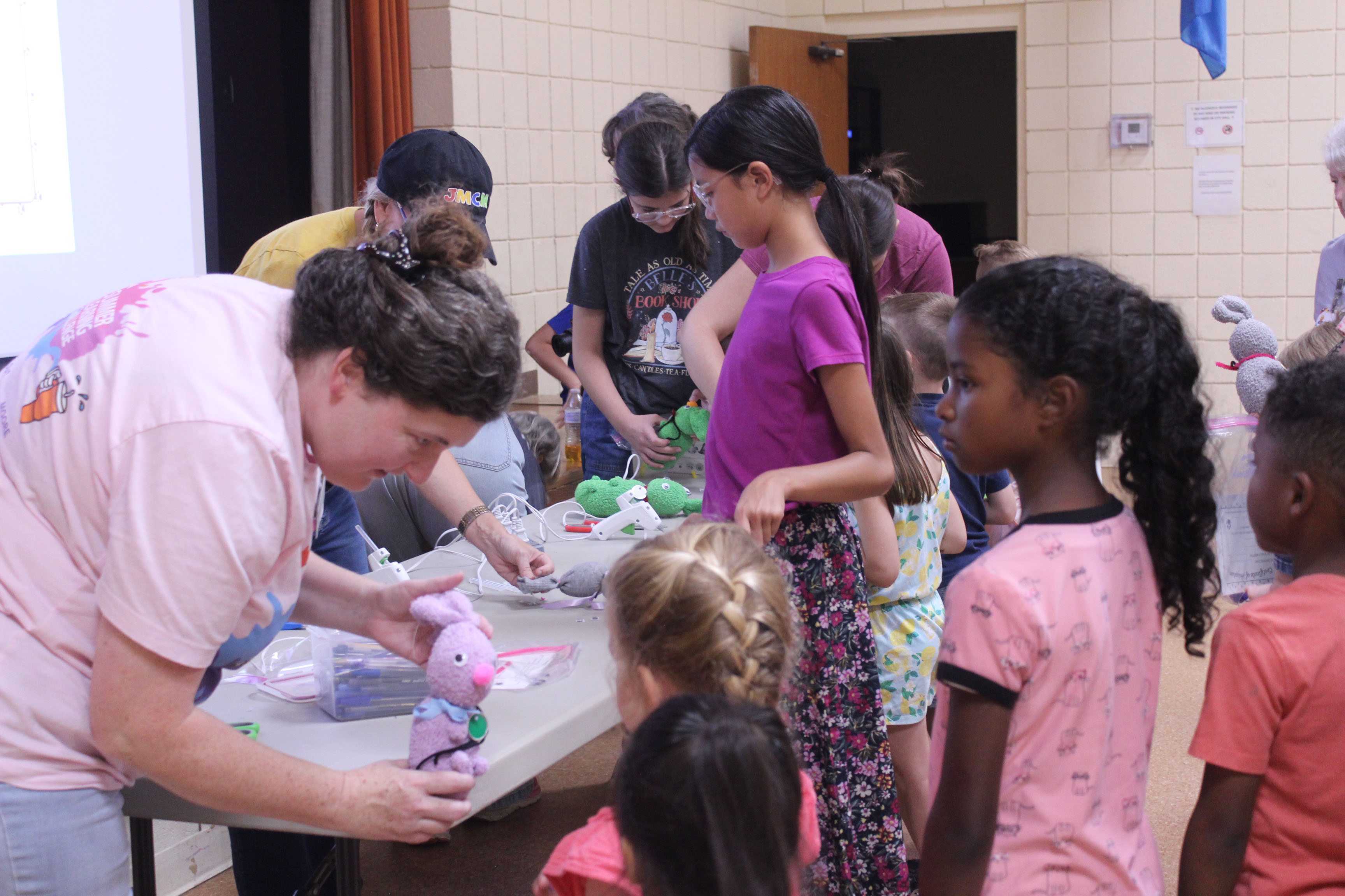 After hot gluing on the eyes, nose and tail and separating the ears, Tecumseh Head Librarian Beth Lyle shows a girl her 'Muttigree' buddy during the Jasmine Moran Children's Museum event at the library on July 17.