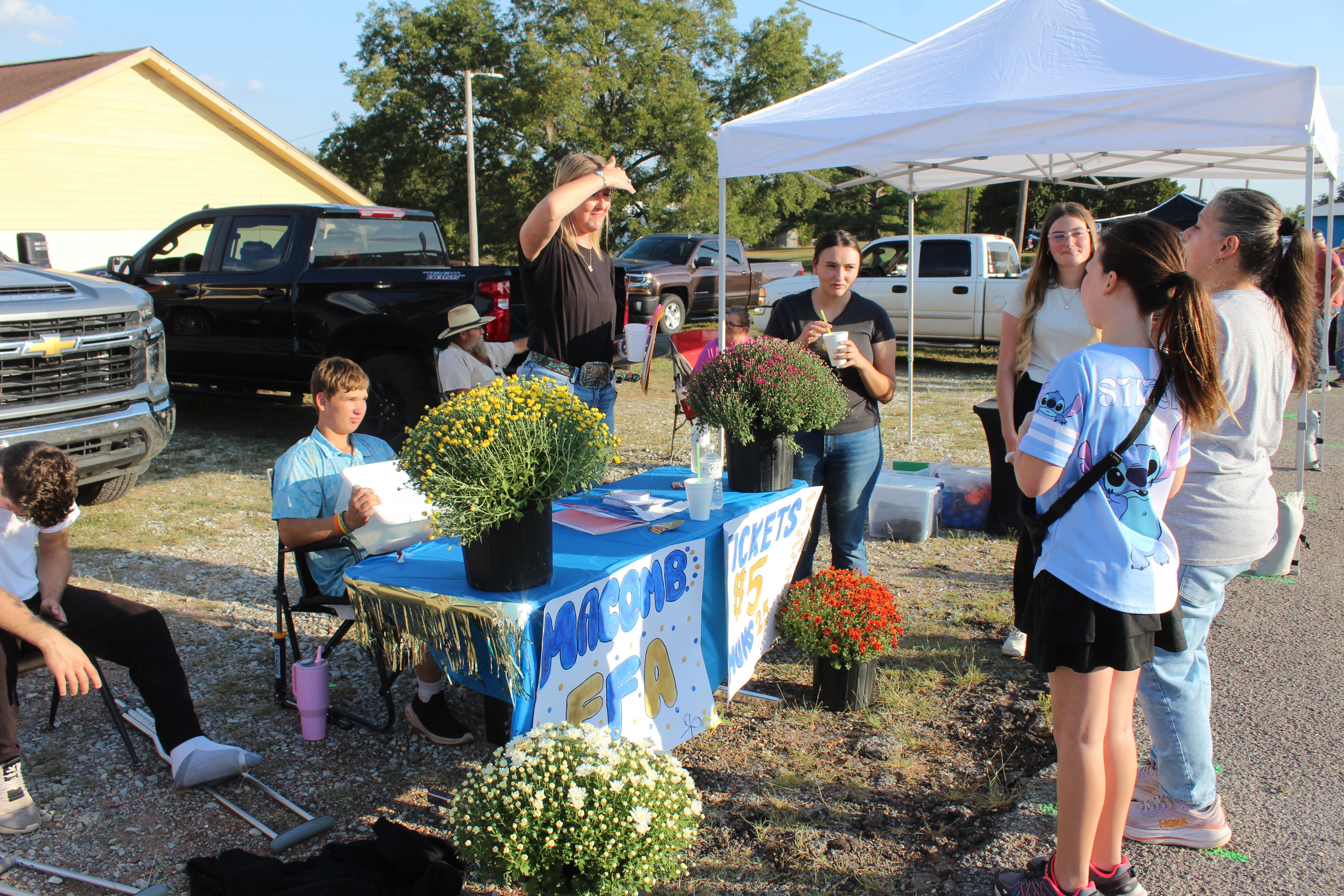 Macomb FFA Advisor Tanna Southerland talks with a woman at the FFA booth during Macomb Trade Days on Sept. 25. They were selling potted mums, as well as tickets to win Blue and Gold meat. The drawing was held that evening, but Southerland said they started with 50 potted mums and will sell them until they run out. If interested, please email her at tanna.southerland@macomb.k12.ok.us. Natasha Dunagan, Countywide & Sun