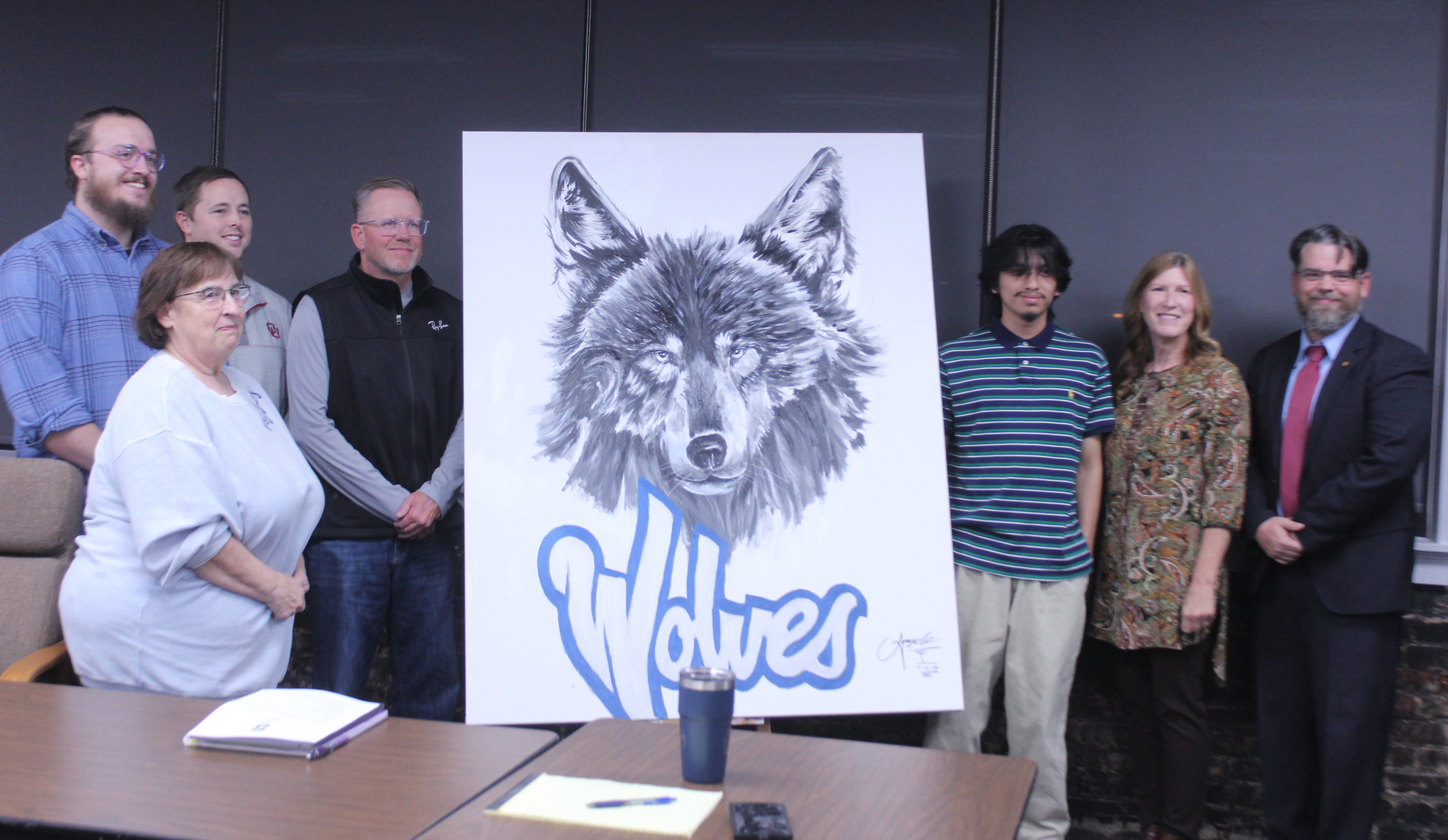 Shawnee High School senior Angel Cazares, third from right, painted this wolf to hang in the Shawnee Public Schools Board of Education room the day before the Nov. 3 meeting. Shown, from left, are board members Turner Bass, Mandy Hillhouse, Casey White, Russ Oliver, Cazares, Jeanne Swinney and President Clif Harden. Cazares also did a live painting of a wolf at the Oct. 21 Community Pep Rally. Natasha Dunagan, Countywide & Sun