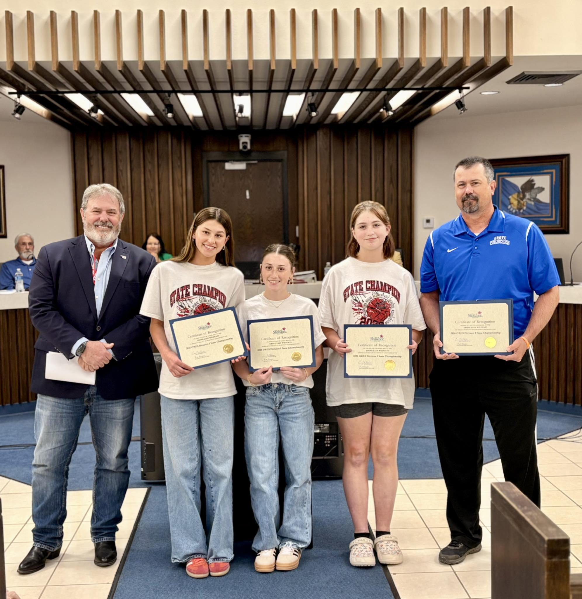 The Shawnee City Commission recognized the Grove Basketball Girls for winning the school's first State Championship. The tournament was hosted by North Rock Creek on Feb. 14. In the first round, they beat Woodall (who had won 14 of the last 16 titles) in the second round, they beat Lone Star, who had beat them twice earlier in the season; they won the Championship game against Marietta 46-22. Shown next to Mayor Eric Stephens is Jacelyn Fichtner, Parker Lilley & Evie Scott with their coach, Chris Pingry.