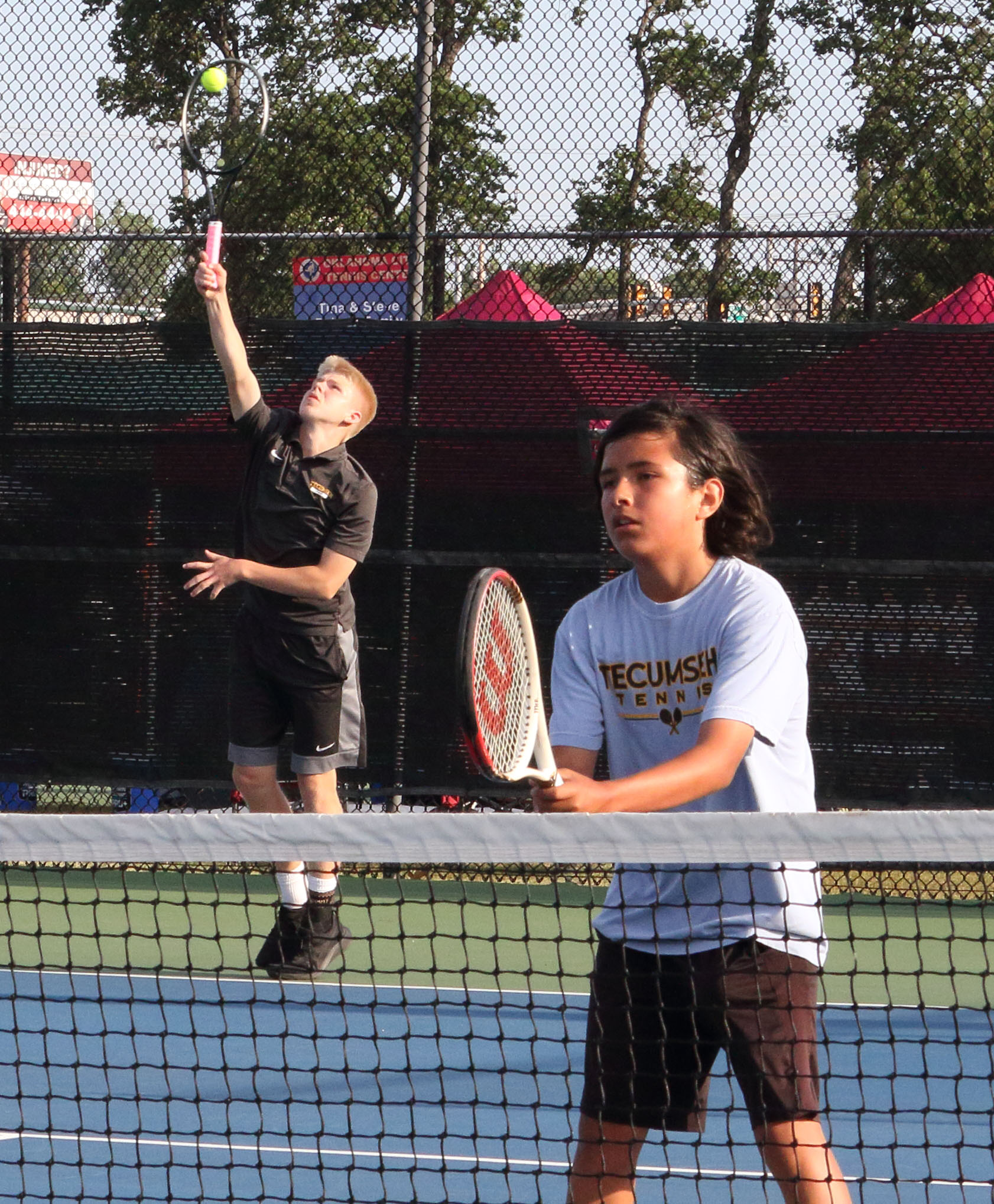 Tecumseh sophomore Jaxon McCullough, left, serves, as freshman Noah Mason stands ready, during the Boys State Tennis Tournament, held at the OKC Tennis Center on May 15. See full cutline below.