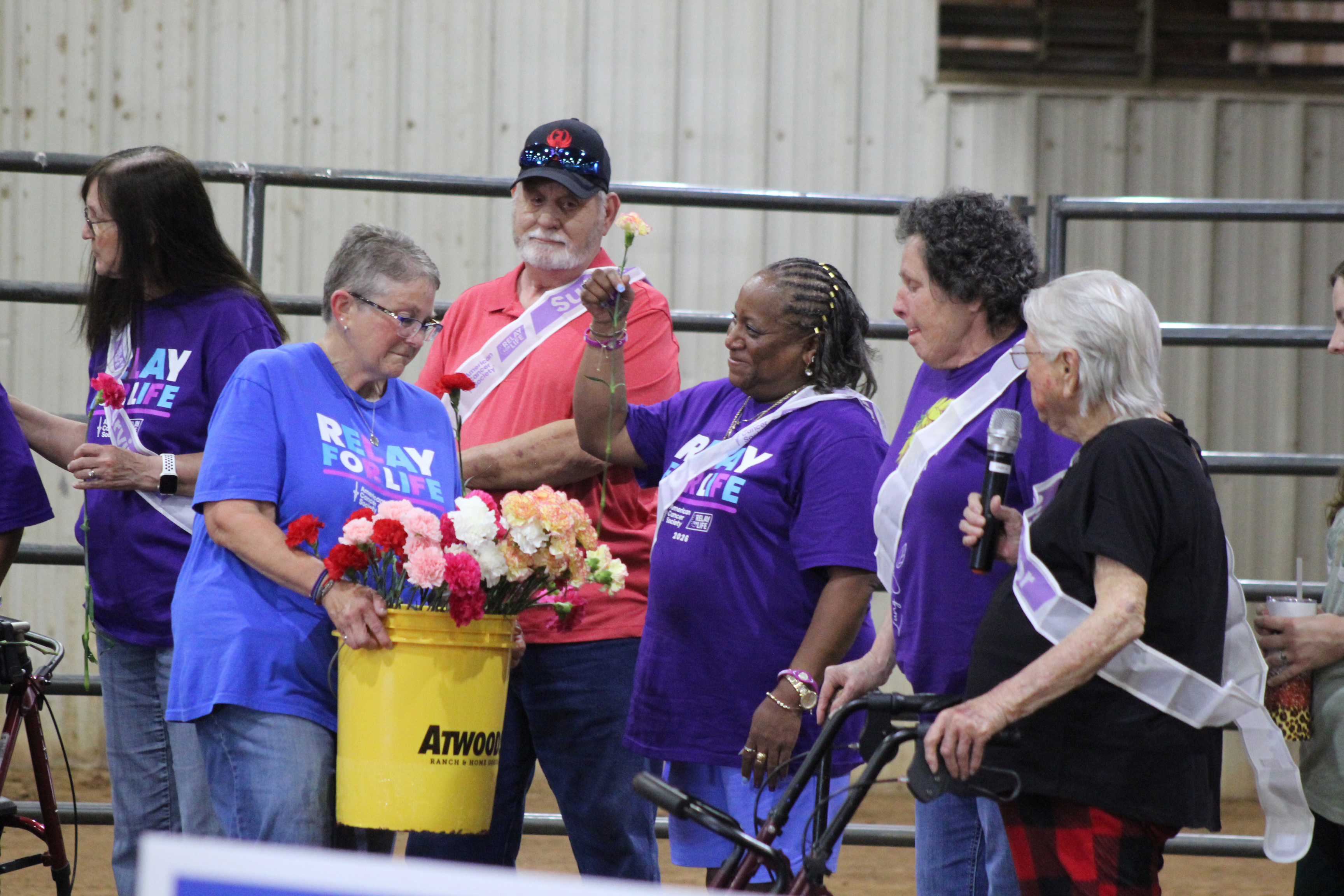 Relay for Life of Pottawatomie County Co-Chair Jana Grubbs hands out carnations to cancer survivors after they tell about their journey during the event, held at the Heart of Oklahoma Expo Center Fred Humphries Arena on May 29. Cancer survivor Nikki Robinson was the speaker that night. There were 54 registered survivors at RFL this year, and 11 area teams raised $28,299 for the American Cancer Society, as of June 1. Photos by Natasha Dunagan, Countywide & Sun
