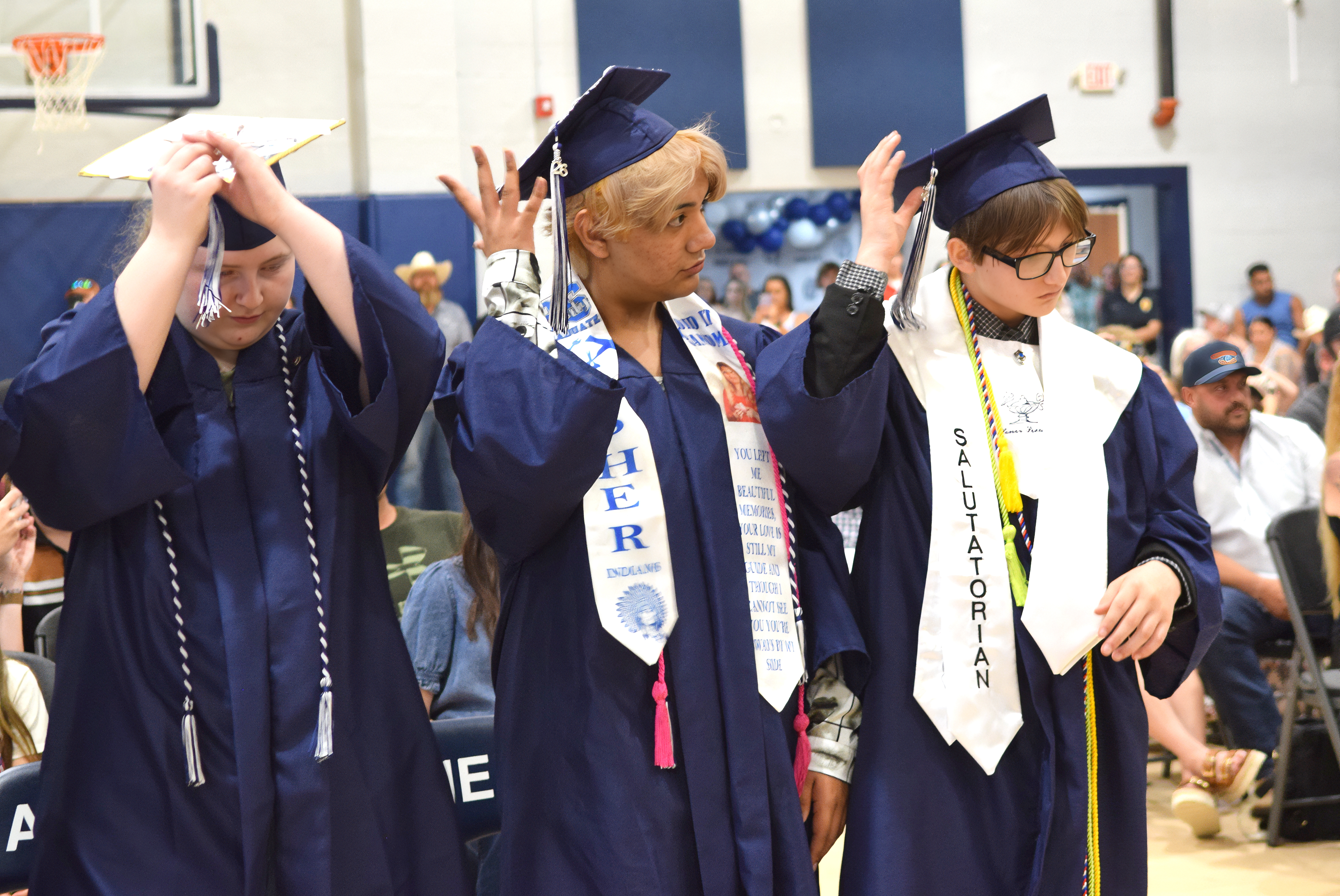 Bethany Idell, J'Kub Medrano and Landon Dodge turn their tassles, signifying their high school graduation.