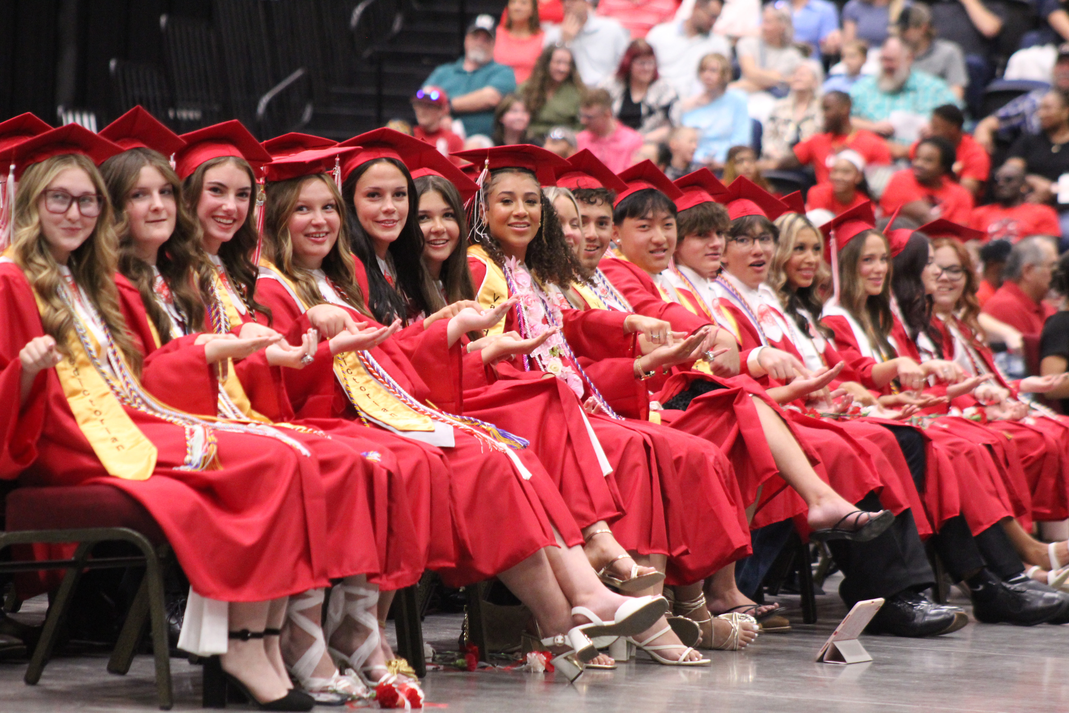 McLoud High School 2026 graduates play the "Gotcha" game, as directed by Senior Class President Mayrin Cerda during graduation on May 23 at FireLake Arena. Cerda told them to look to their neighbor and say, "I'm gonna get you," then try to pull their finger away before their neighbor could grab it.