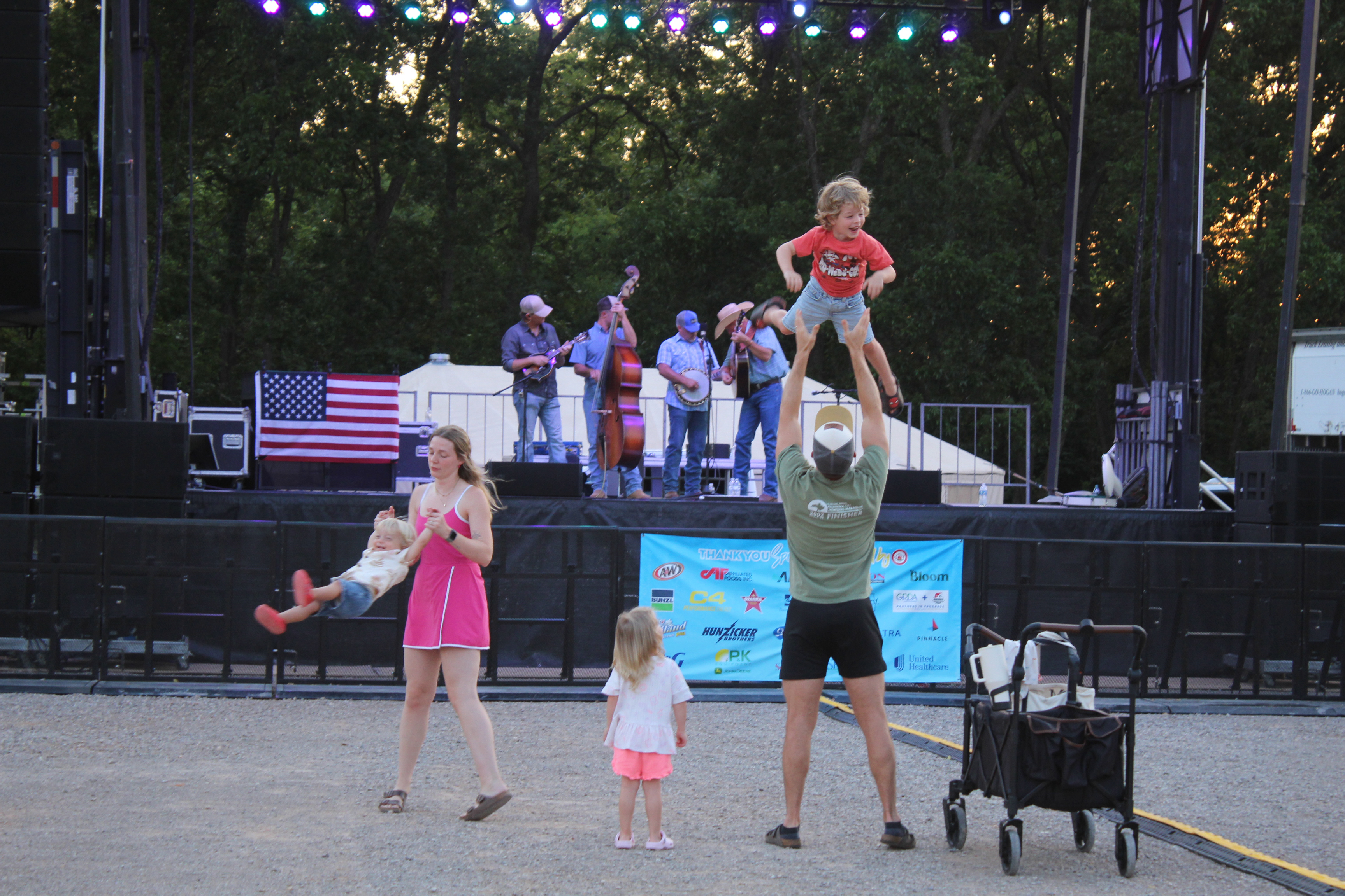 Morgan and Gage Bullard, of Edmond, swing and toss two of their three children, ages 1, 3 and 4, as Oklahoma Line performs "Before I Met You" on Friday night, Aug. 7, during the FireLake Fireflight Balloon Festival. Kaleb Austin and Austin Snell also performed at the festival on Aug. 8 at the CPN Festival Grounds in Shawnee. Photos by Natasha Dunagan, Countywide & Sun