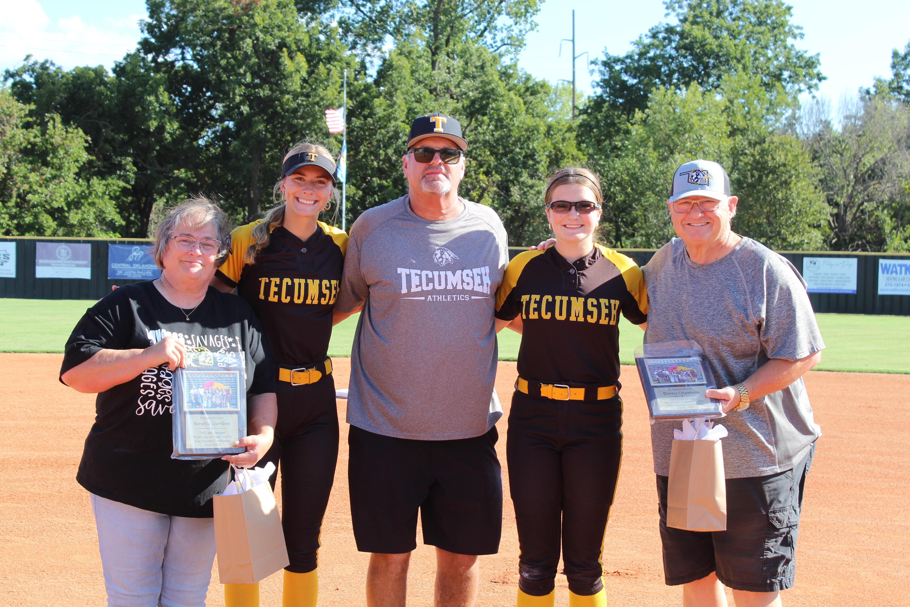 Photographer Kenetta Lisenbee, far left, and Countywide & Sun Reporter Danny Chambers, far right, were honored with plaques of appreciation before the Sept. 14 Tecumseh High School fast pitch home game. See full caption below.