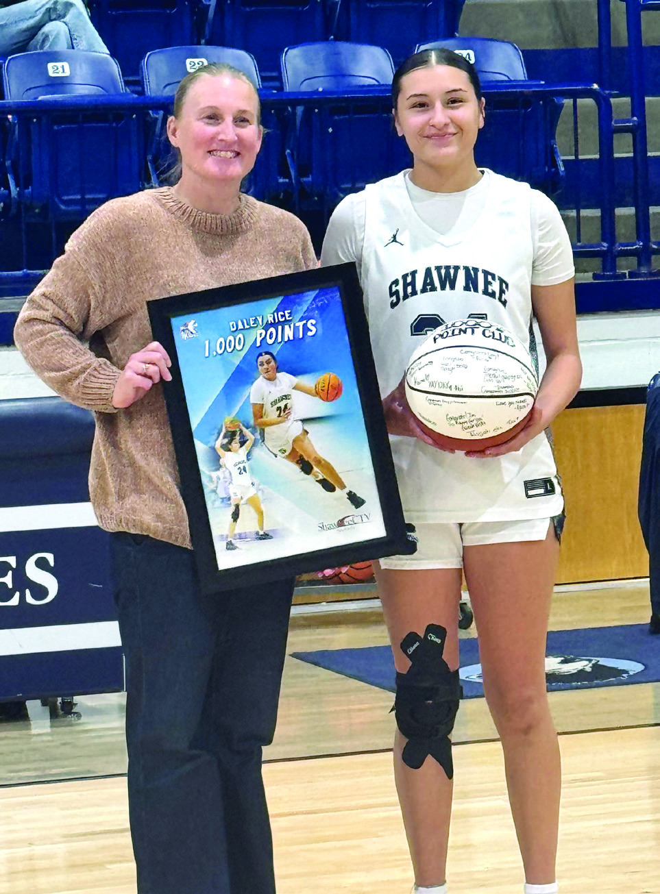 Coach Wendi Wells presents Shawnee senior Daley Rice with a framed photo and a game ball in recognition of Rice reaching 1,000 high school career points in January. Photo provided by Shawnee Public Schools