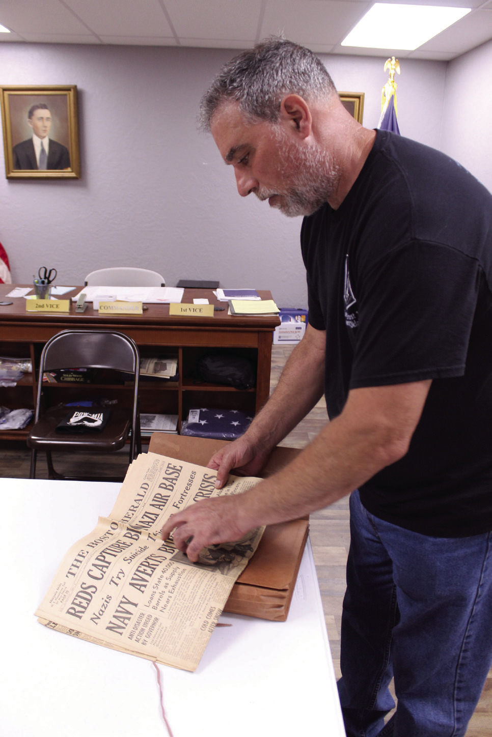 American Legion Post 16 Past Commander Keith DiPatri shows one of the many historic newspapers which have been donated to the post's collection. Several documents, photographs and military items have been preserved and displayed since the April 2023 tornado. Photos by Natasha Dunagan, Countywide &amp; Sun