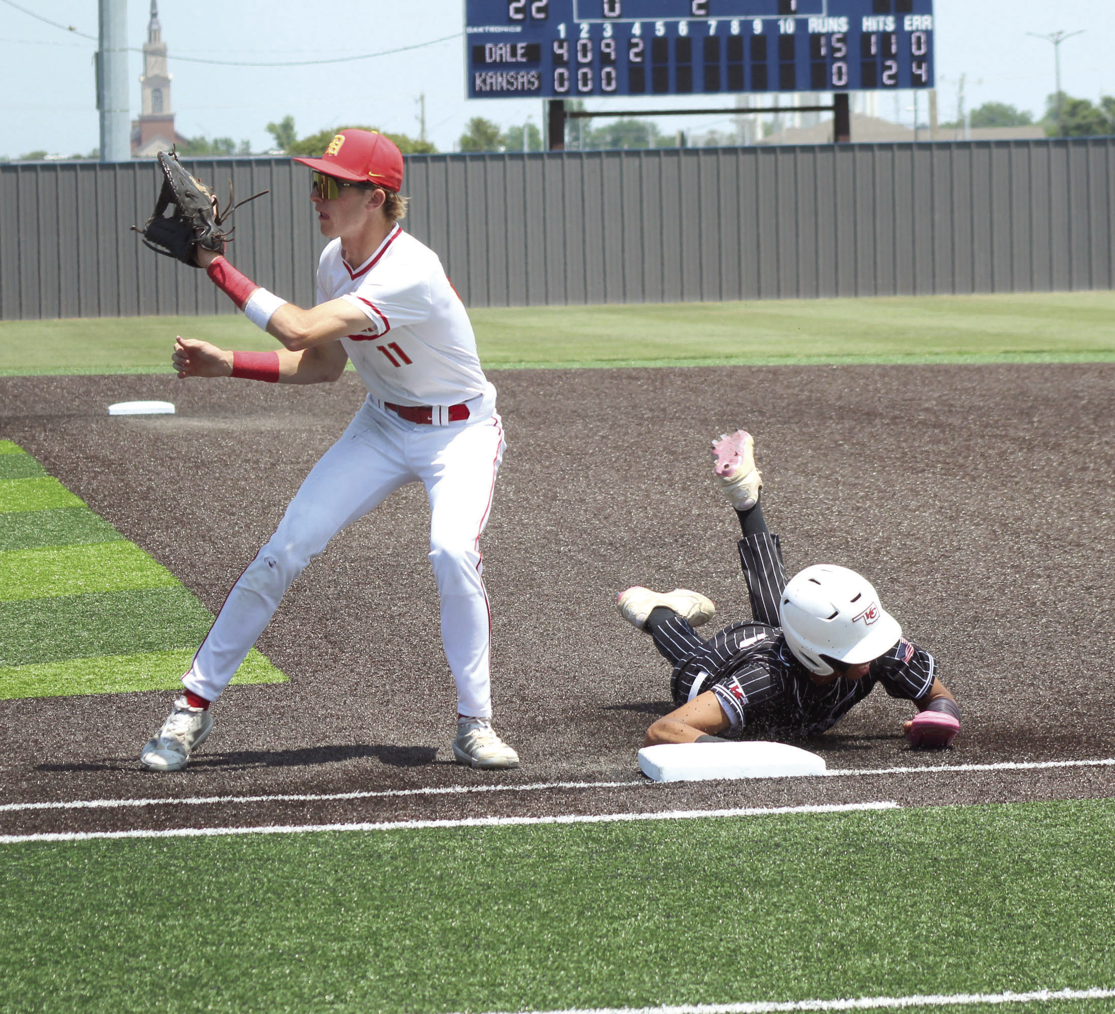 Dale junior Chase Harris waits for the catch, as a Kansas runner dives back to first, in the fourth inning of the Class 2A1 State Baseball Quarterfinal game, held at Shawnee High School on May 14.