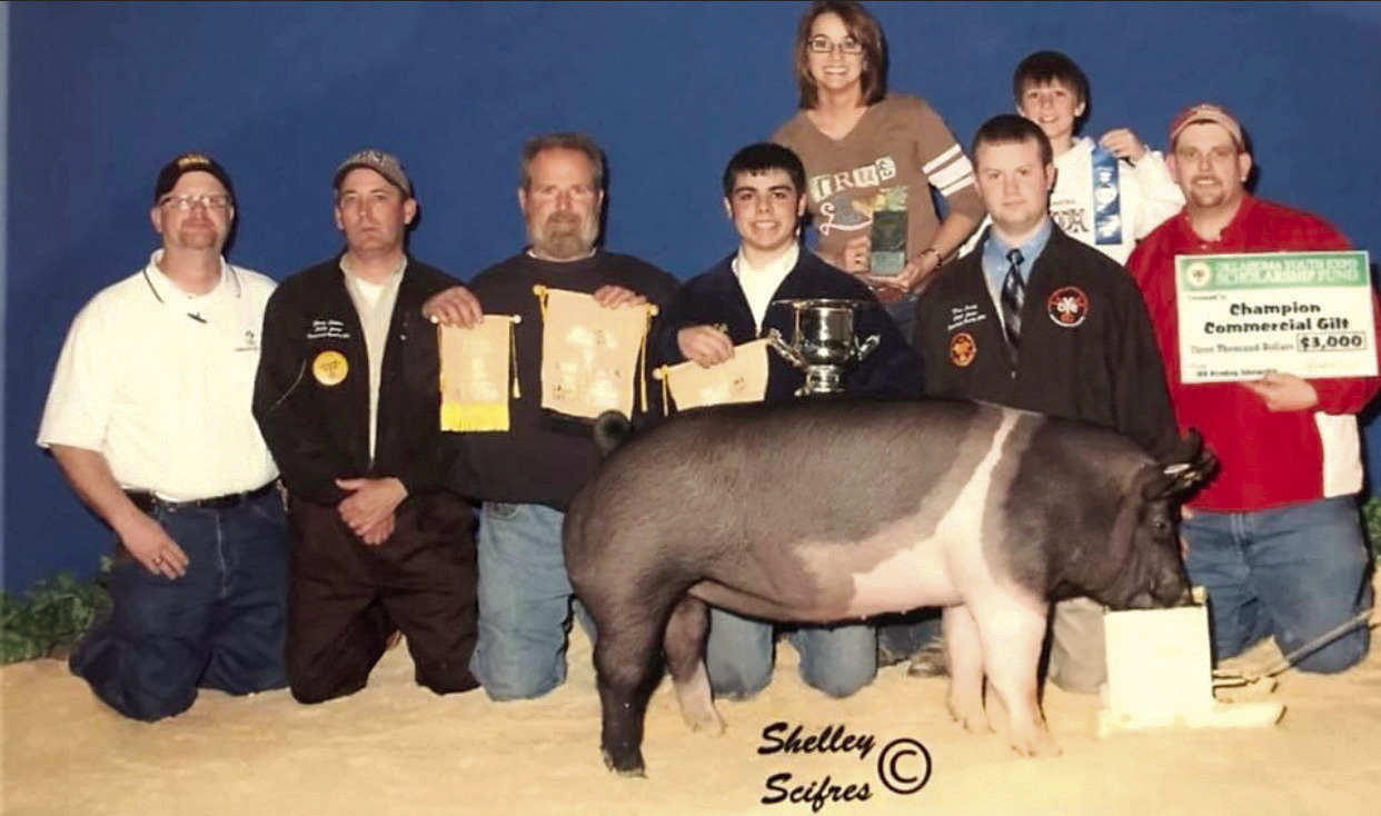 Steve Flowers, far right, holds a presentation check from the Oklahoma Youth Expo Scholarship Fund for Prague student, Adam Holik, and his Champion Commercial Gilt. Flowers has good memories of Holik’s work ethic from when he was the Agriculture teacher at Prague, from 200710. Now, Flowers is getting back into teaching as the new Agriculture teacher at McLoud High School. Photo provided.