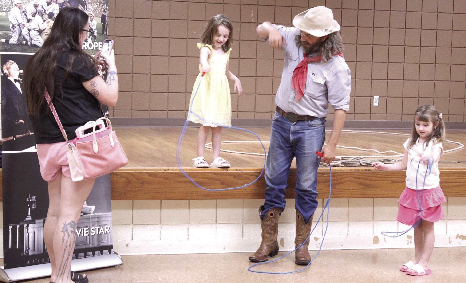 Buckaroo Bart, aka Bart Taylor with the Will Rogers Museum and Oklahoma Historical Society, teaches Maxxine Fox, 4, and Lydia Fox, 5, both of Shawnee, their first rope trick during the