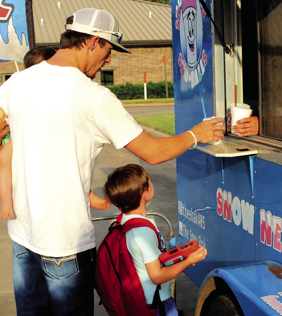 A family gets their free snow cones from The Snow Shak during the Sixth Annual Shawnee BancFirst Back to School Bash on Aug. 6. In addition to free snow cones, BancFirst gave away free hot dogs and backpacks full of school supplies. Shannon Chandler, BancFirst Regional Sales and Marketing Coordinator, said they had between 100 to 150 people attend the Shawnee event and around 100 in total at the Tecumseh and Mc-Loud events this year. Natasha Dunagan, Countywide &amp; Sun