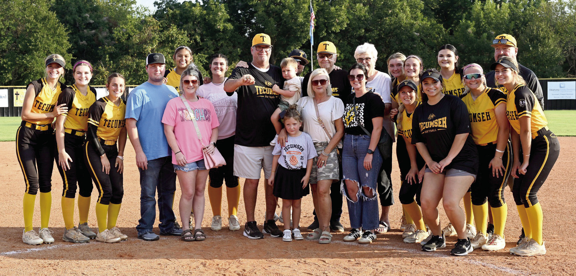 Tecumseh Fast Pitch Head Coach Chad Trahan poses with his team and his family, as he shows his Oklahoma High School Fastpitch Softball Coaches Hall of Fame ring at the home game with Berryhill on Sept. 16. Trahan was inducted into the Hall of Fame in June. He also received a game ball for winning 500 games that day. Photo courtesy of Kenetta Lisenbee