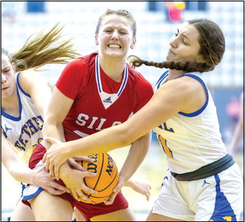 Pictured left, Bethel sophomore Josie Megehee, far left, and senior Hannah Davidson, far right, fight to take control of the ball from a Silo player in the Class 3A Area game, played at Jenks on March 3. The Lady Wildcats won, 60-54, and will compete in the State Tournament today (March 9), 4:30 pm at the State Fairgrounds Arena. Photo provided by Richelle Treece.