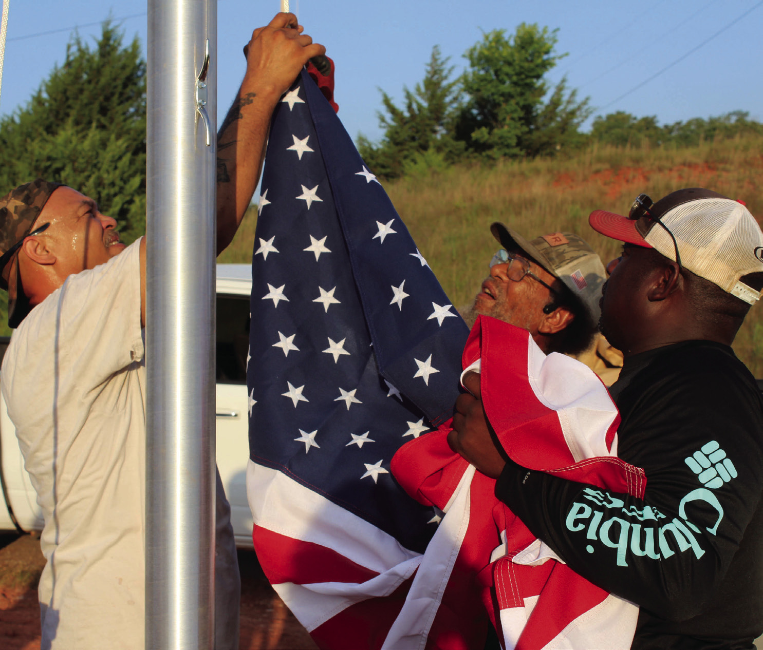 Shawn Edwards, Franklin Edwards and Clarence Bernard attach the U.S. flag to hoist it for the first time on a newly installed 25-foot flagpole at the Brooksville town limits, June 28. File photo