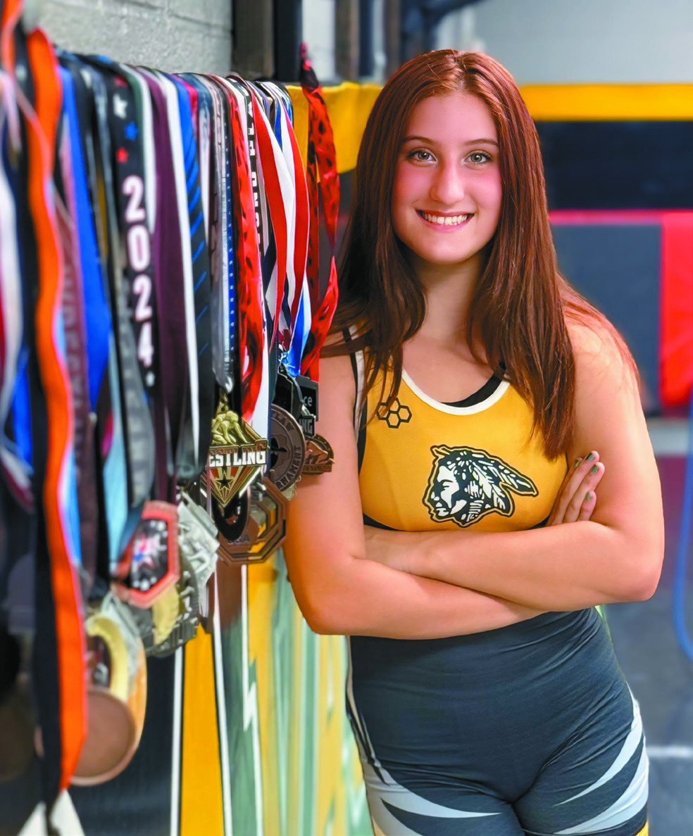 Kylei Gokey poses for a professional photo in her Tecumseh High School singlet and with the 35 medals she's won so far. Gokey has been wrestling since seventh grade and will go into her sophomore year, having been a state-qualifier as a freshman and having competed at national tournaments in Fargo, ND, and Westfield, IN, over the summer. Photo provided