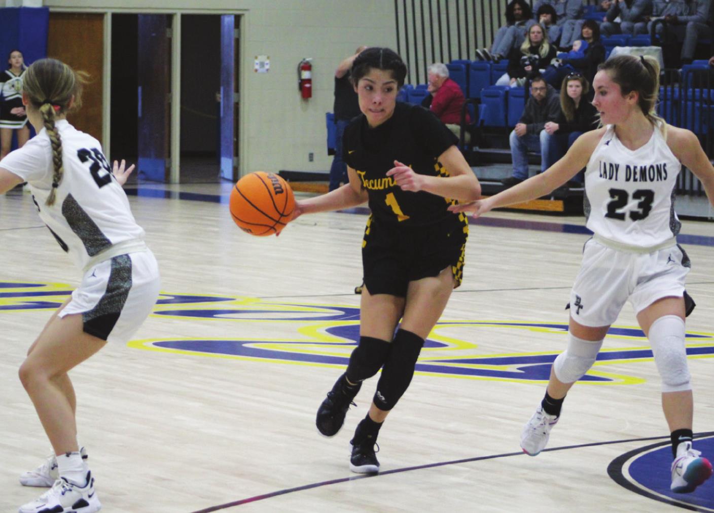 Tecumseh’s Serenity Jacoway dribbles between two Perkins-Tryon players on her way to the basket during the First United Bank Classic consolation championship round in Bethel on Dec. 11. The Lady Savages won that game, 39-35. They lost to Byng in the first round on Dec. 9, 37-54, and won against Bridge Creek, Dec. 10, 74-32. Countywide &amp; Sun/Natasha Dunagan