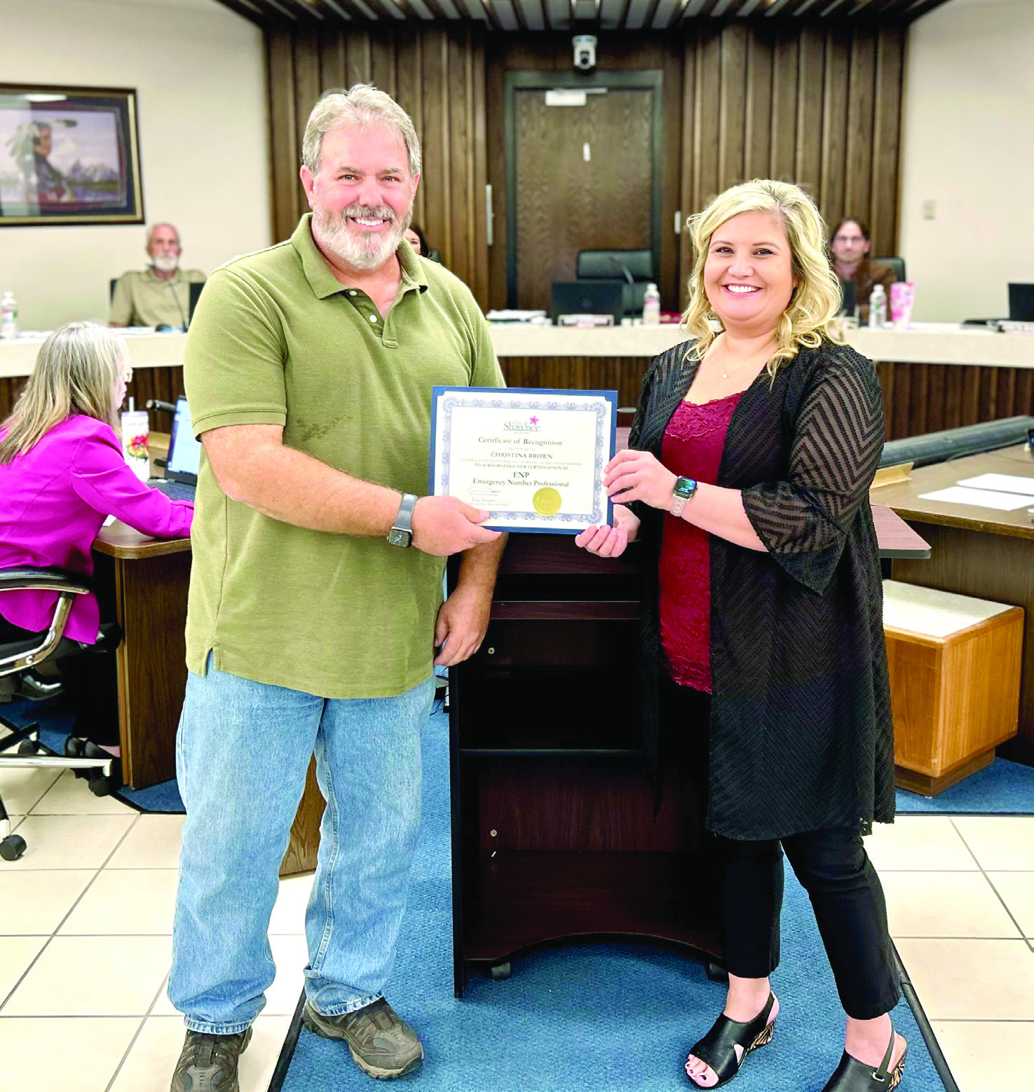 During the Shawnee Board of City Commissioners meeting held Monday, Oct. 21, Mayor Eric Stephens presented a Certi_cate of Recognition to Shawnee Police Department’s Communication Manager Christina Brown (right) for receiving the Emergency Number Professional Certi_cation. Photo provided