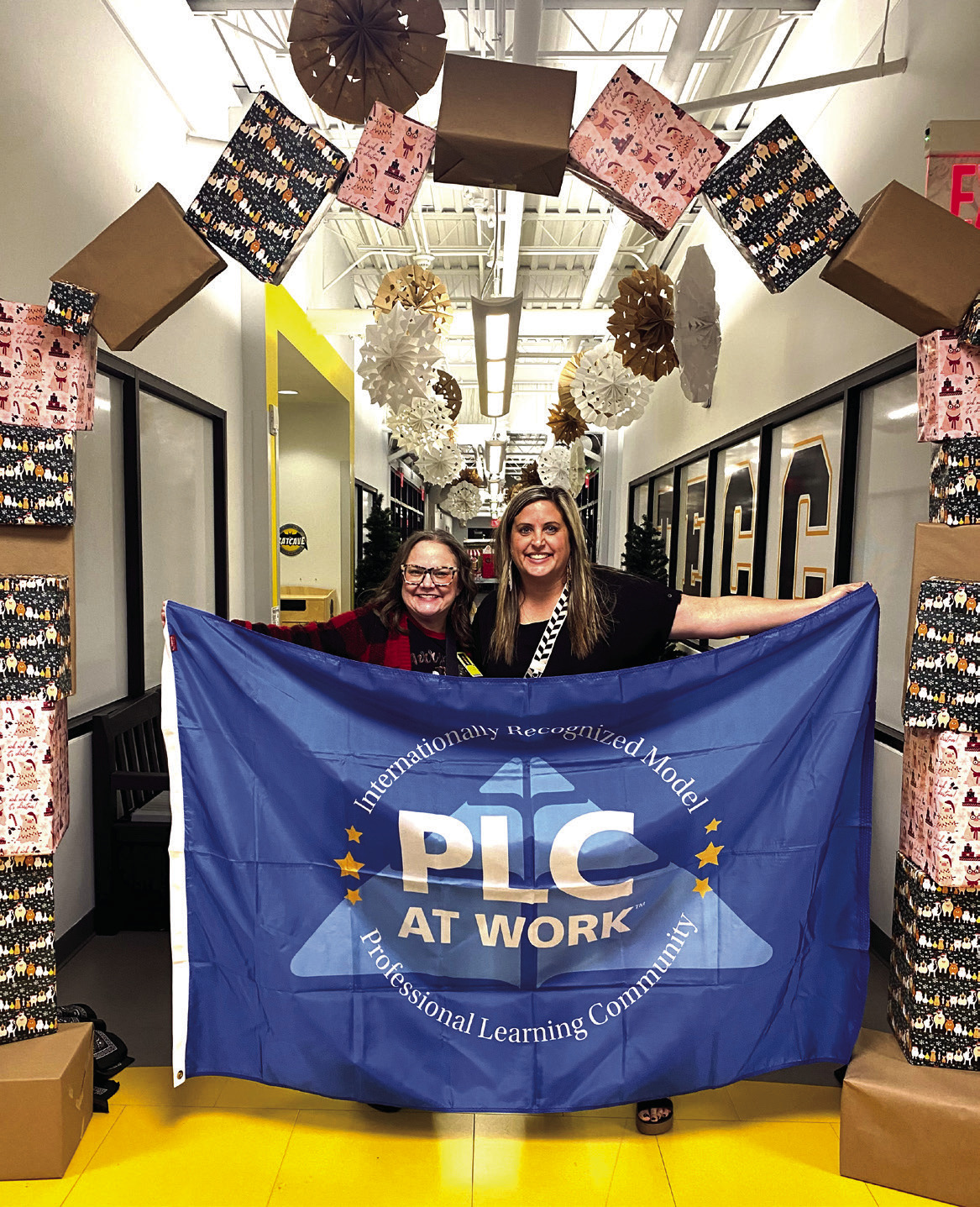 Tammy Giaudrone, Principal at Tecumseh Early Childhood Center, and Ashley Steward, Intervention Specialist proudly display the flag they were awarded last month to represent their achievement as a Professional Learning Community award recipient. Julie Talton, Countywide & Sun