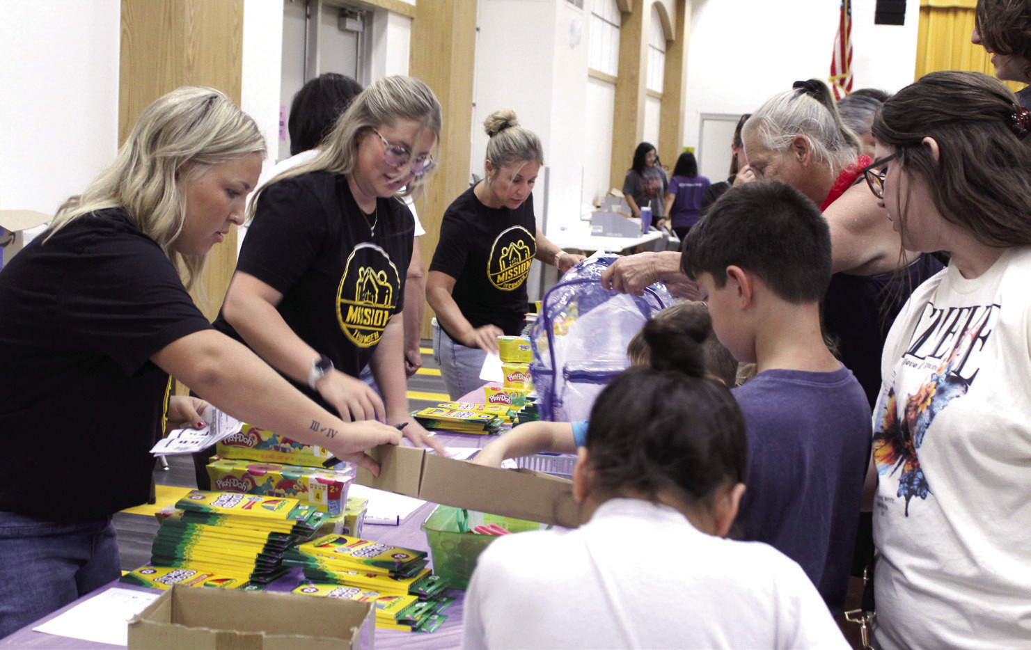 Twins Elise Whitney and Ella (Whitney) Gardner and their mother, Hope Whitney, volunteer at the Mission Tecumseh Back to School Bash, held at the Tecumseh High School W.P. Wood Alumni Center on July 25. Photos by Natasha Dunagan, Countywide & Sun