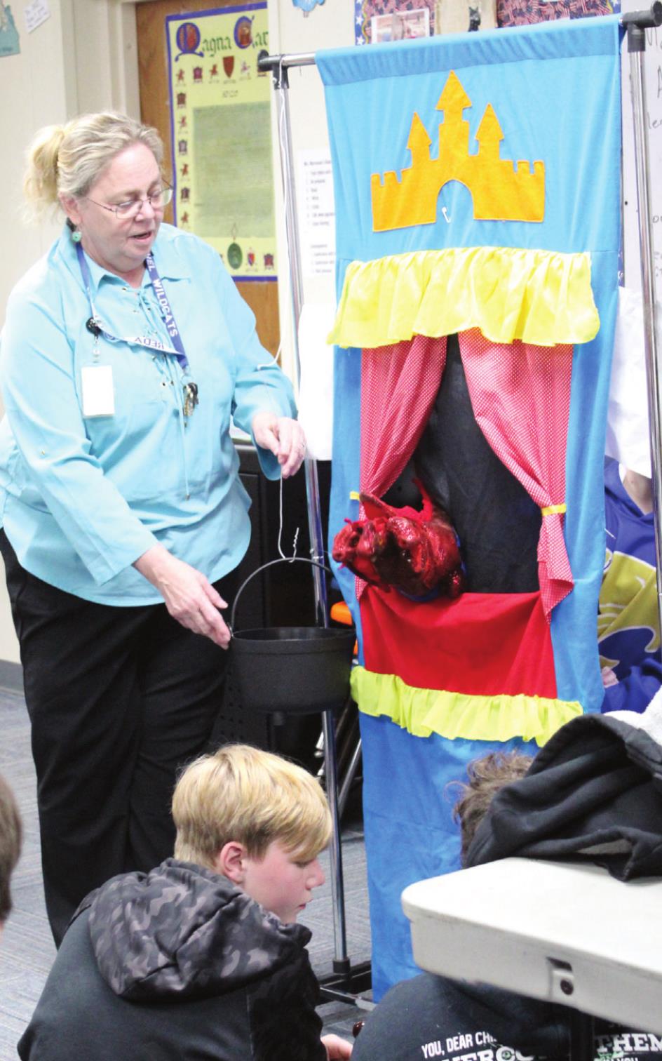 Bethel Middle School Teacher Reda Marcussen helps with a bucket as two of her sixth-grade drama students practice their puppet show on April 11. Marcussen recently won the POE Excellence in Education Junior High Educator Merit Award and was named the Teacher of the Year. Countywide &amp; Sun/Natasha Dunagan