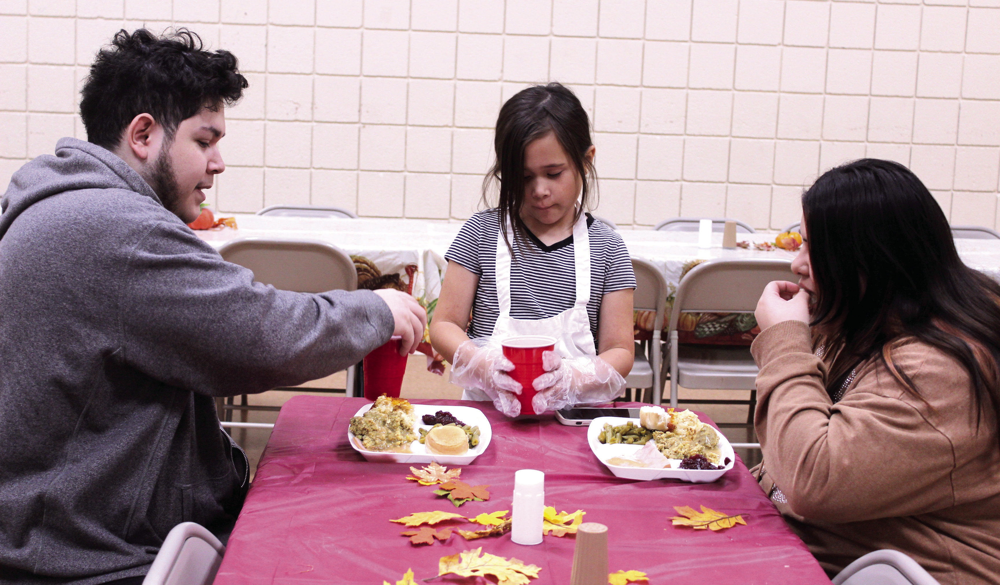 Madisyn Castaneda, 10, serves drinks to Jimmy and Unity Alas of Maud during the 20th Anniversary Tecumseh Family Thanksgiving Dinner, held at the Tecumseh City Hall Auditorium on Nov. 27. U. Alas said she used to come to the dinner with her father and grandmother, and decided to introduce her husband to it this year. Castaneda was volunteering for the first time with her two sisters and her parents, Daniel and Amber Castaneda. Natasha Dunagan, Countywide & Sun