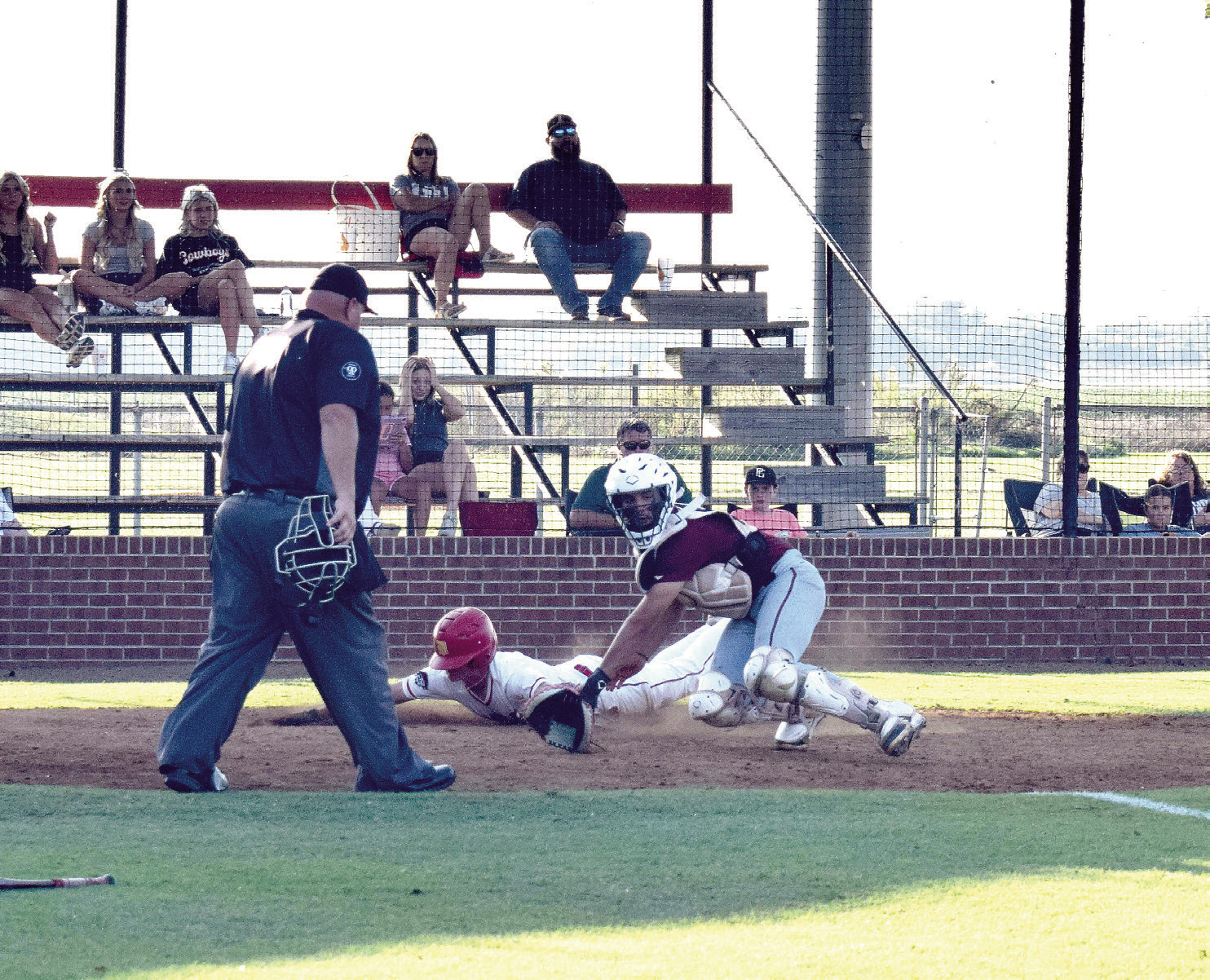 Dale's Andrew Collins slides across home plate ahead of the ball to score for the Pirates.