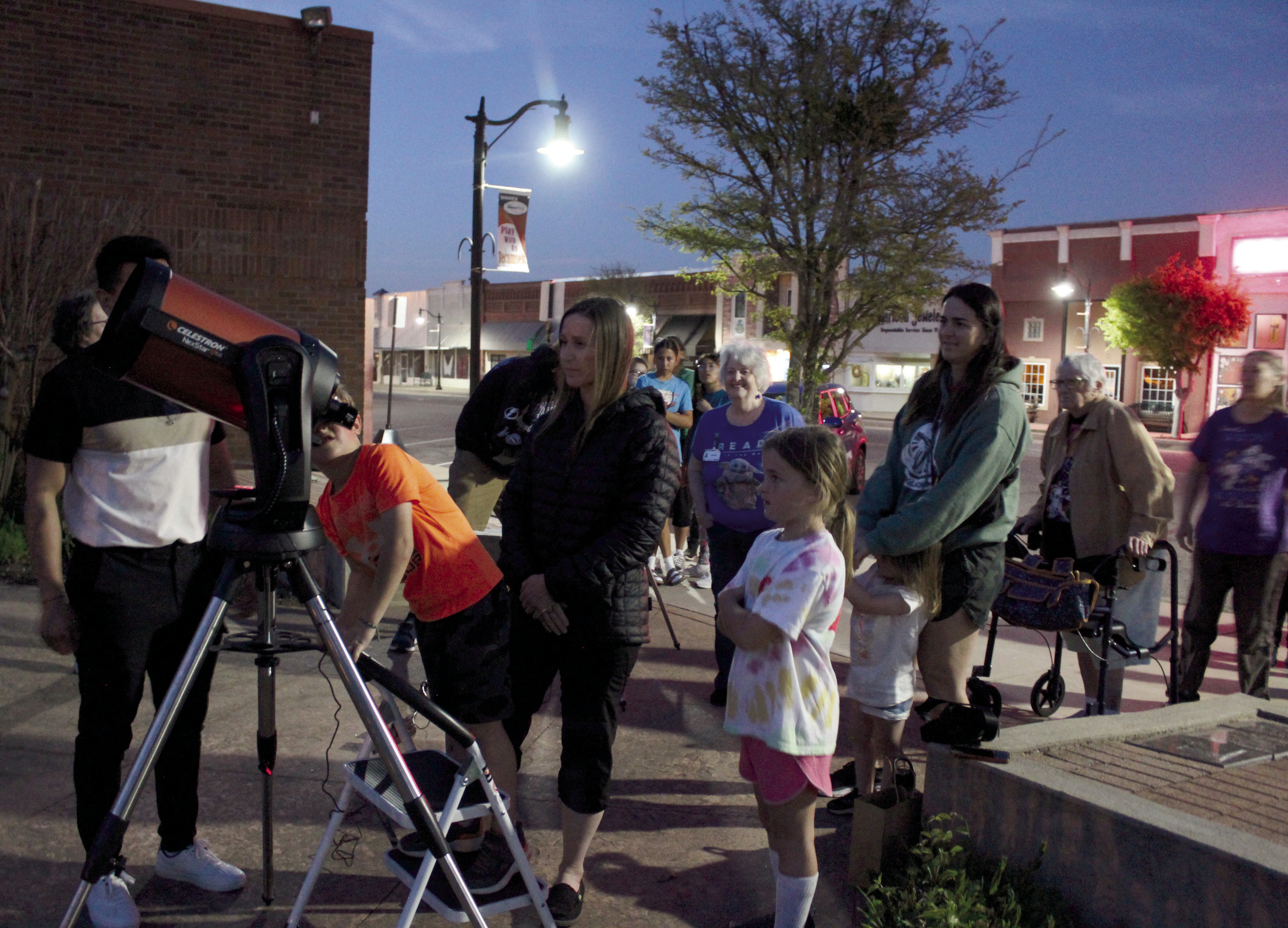Clancy Humphrey, 6, of Shawnee, looks at Jupiter through a telescope belonging to the Lunar Sooners club from OU, as his mother Bethany Humphrey watches, during a star gazing event at the Tecumseh Public Library on April 5. The Lunar Sooners were represented by graduate students Manuel Barrientos (behind telescope) and Adam Moss, who spoke earlier on the science behind an eclipse and astronomy. Countywide & Sun/ Natasha Dunagan