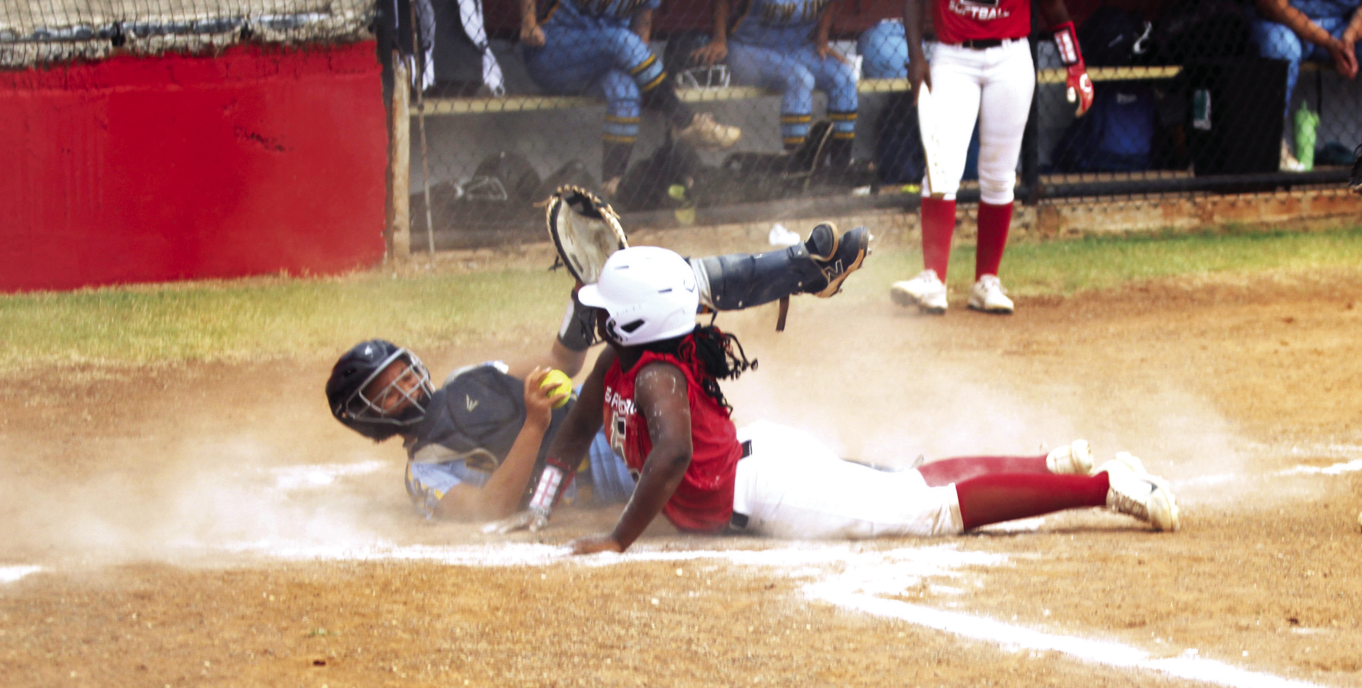 Earlsboro freshman Zory McGregor dives across home plate as the New Lima catcher tries to tag her during the home fast pitch game on Aug. 11. The Lady Wildcats won, 10-0.